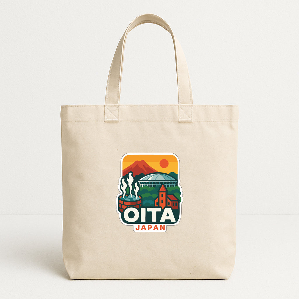 A beige tote bag with a graphic design featuring a mountain landscape, buildings, and the text "OITA JAPAN".