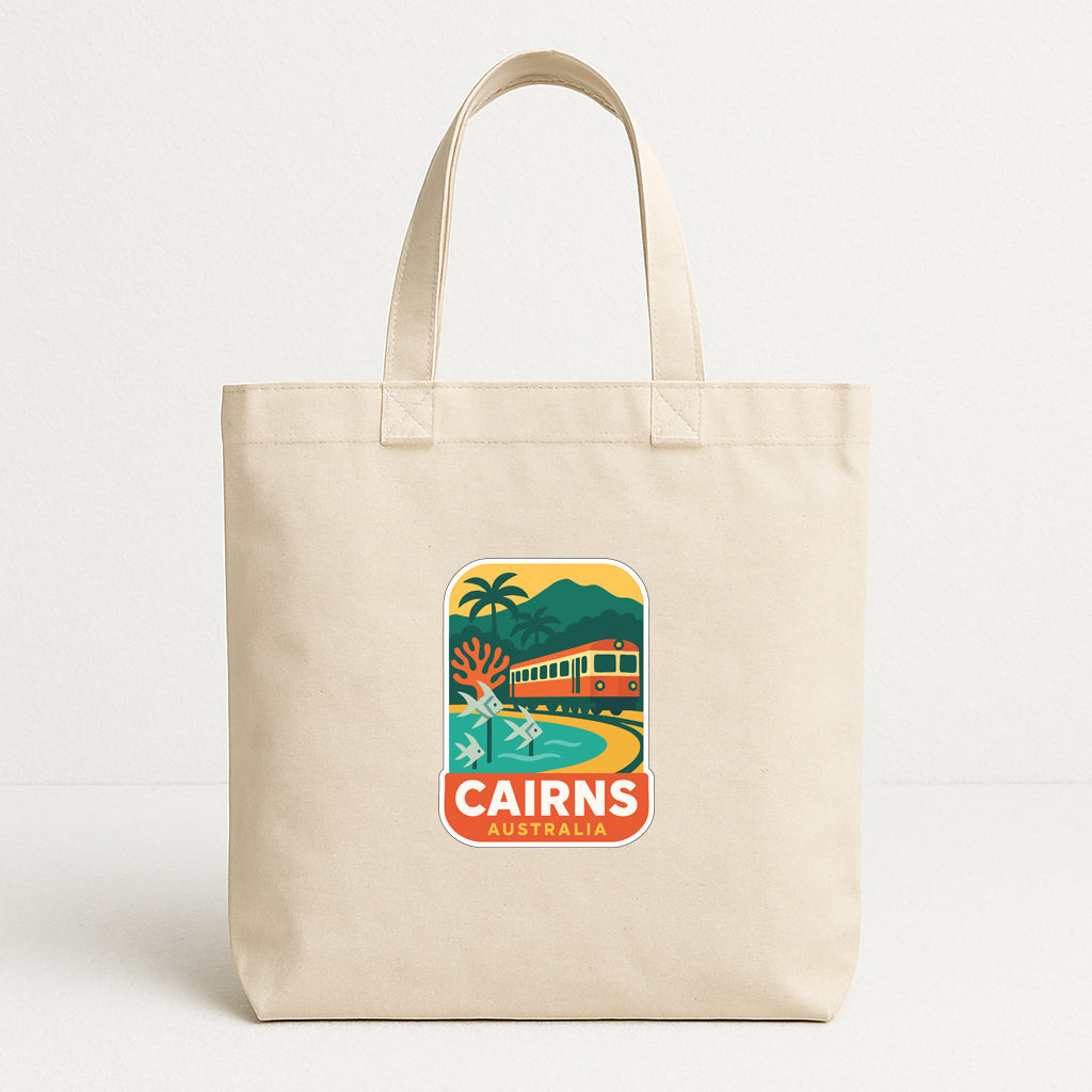 A beige tote bag with a printed design depicting a tropical beach scene and a train, along with the text "CAIRNS AUSTRALIA".