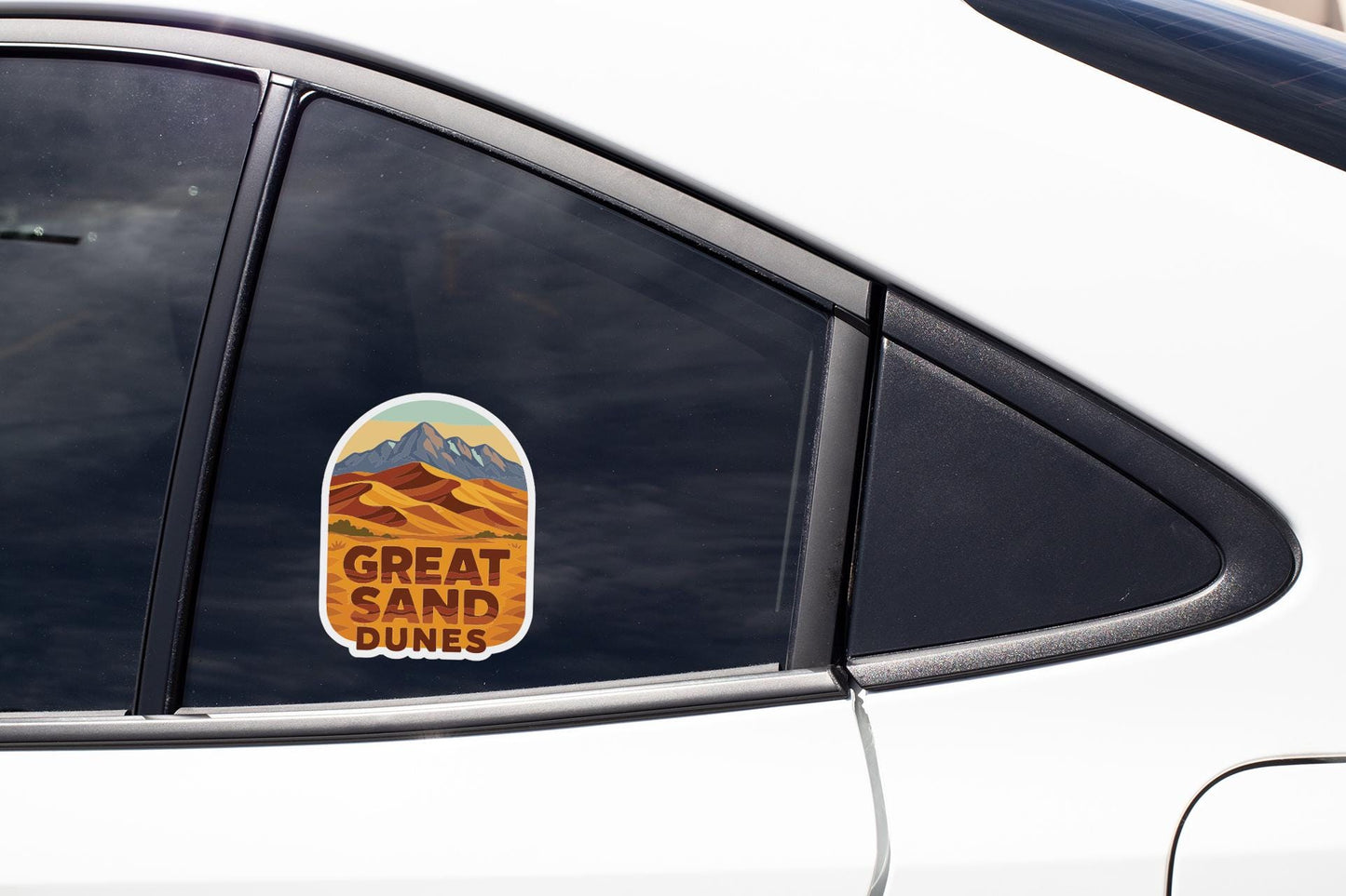 A sticker on the side of a car window that says "GREAT SAND DUNES".