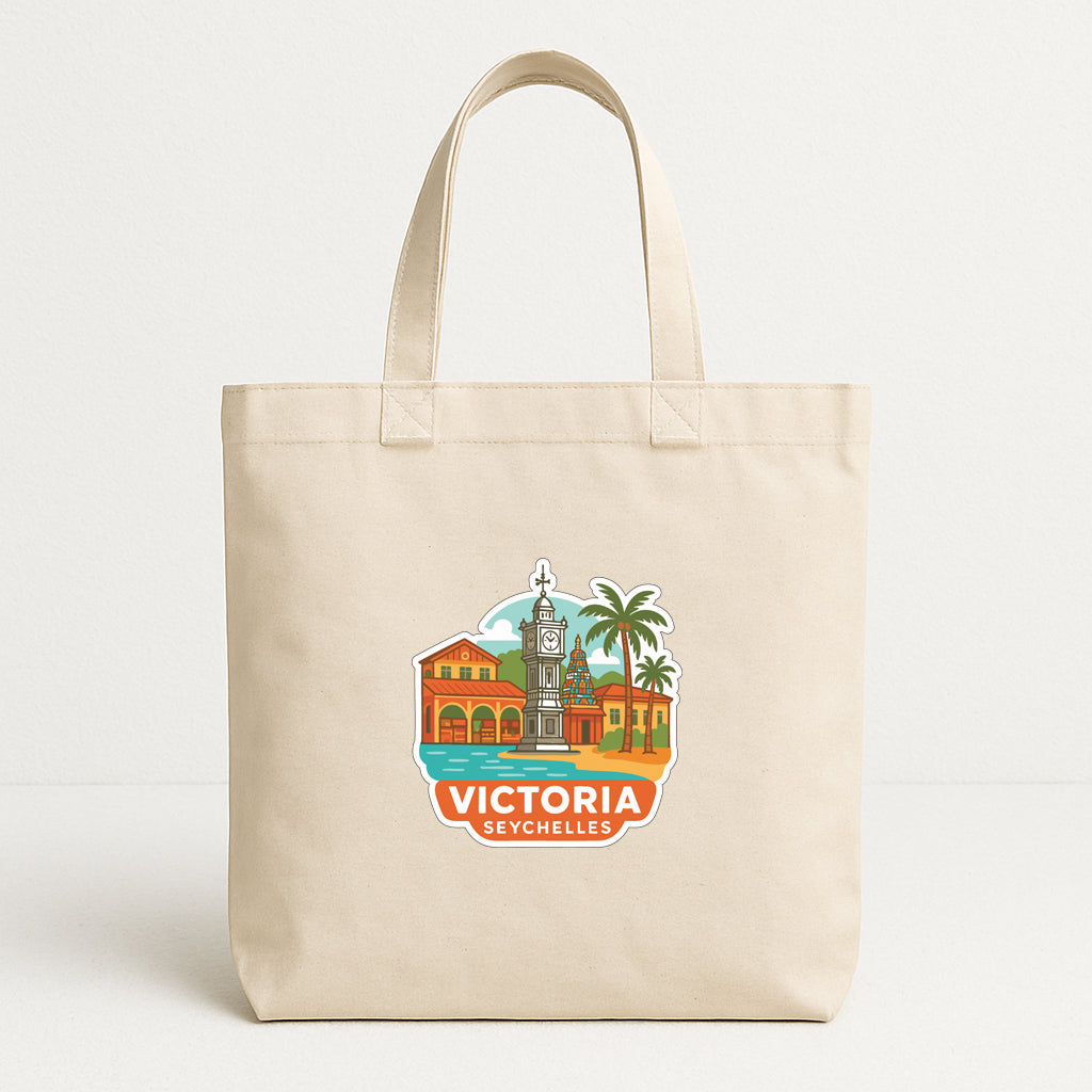 A beige tote bag with a printed design depicting a cityscape and a clock tower, along with the text "VICTORIA SEYCHELLES".