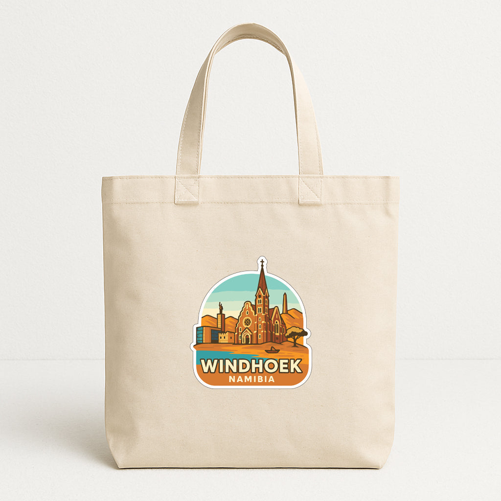 A beige tote bag with a graphic design depicting the Namibia skyline, featuring a church spire and other landmarks.