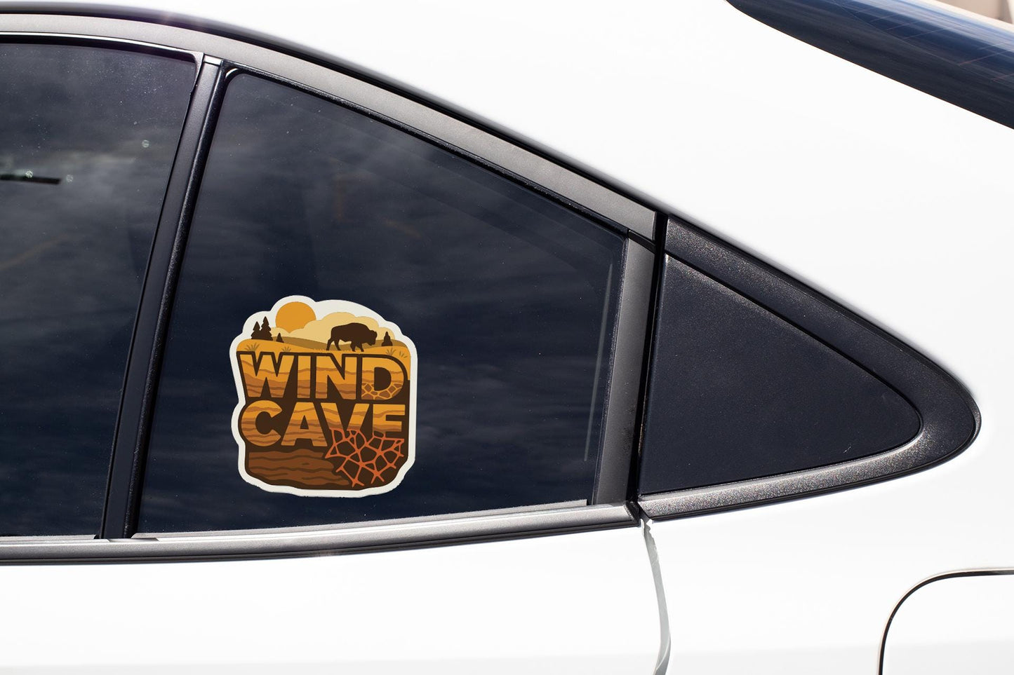 A car window with a sticker on it that says "WIND CAVE".