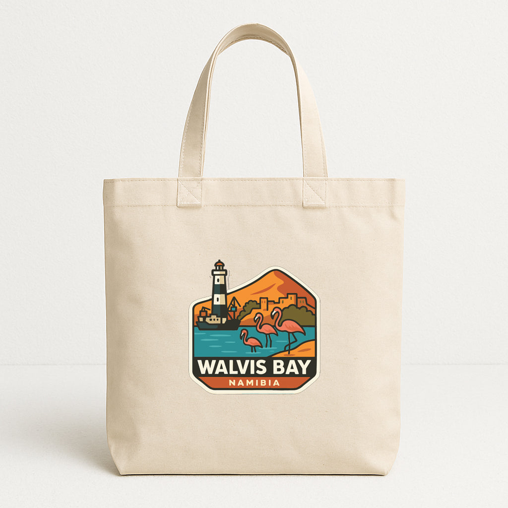 A beige tote bag with a printed design depicting a lighthouse and flamingos in a tropical setting, along with the text "WALVIS BAY NAMIBIA".