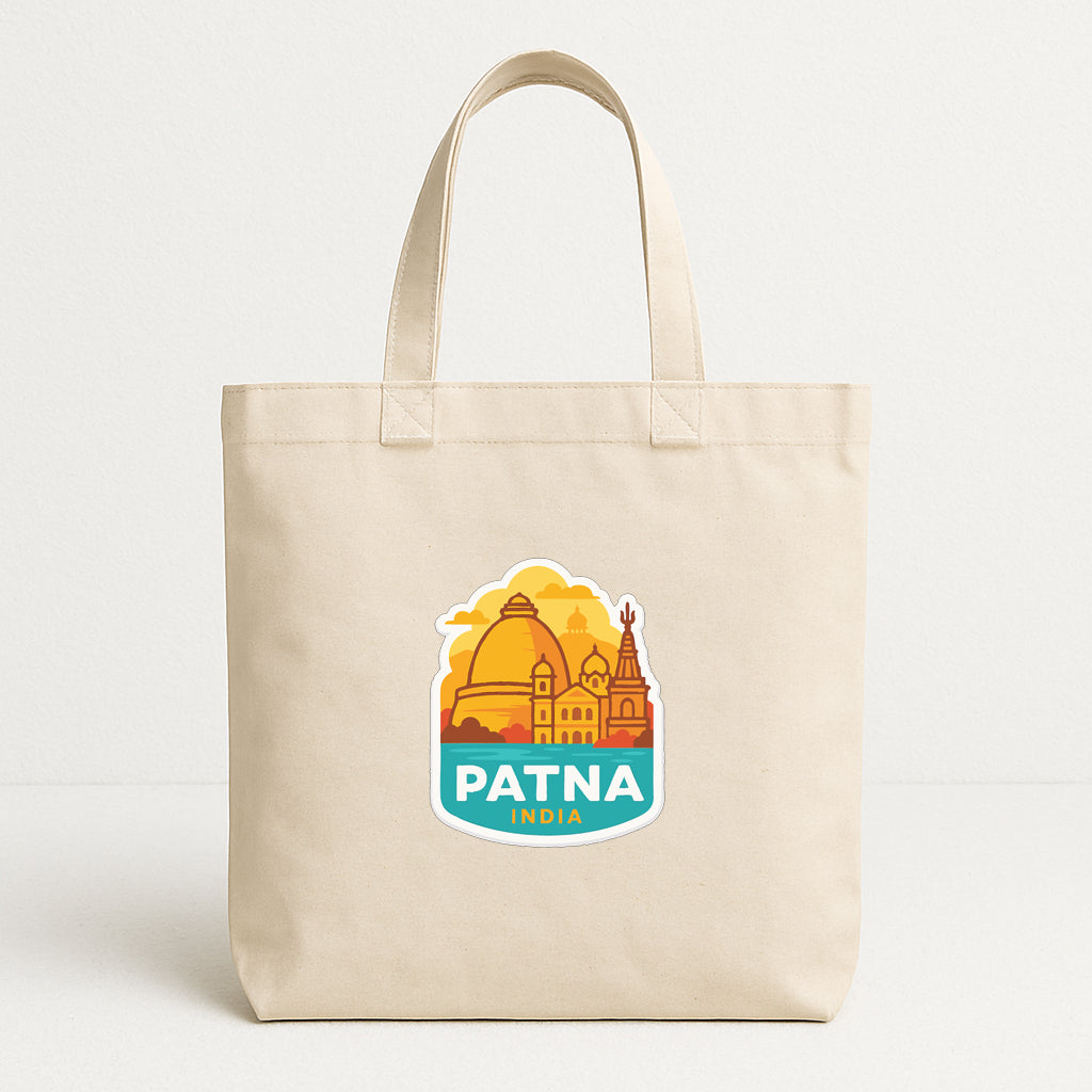 A beige tote bag with a sticker depicting the city of Patna, India.