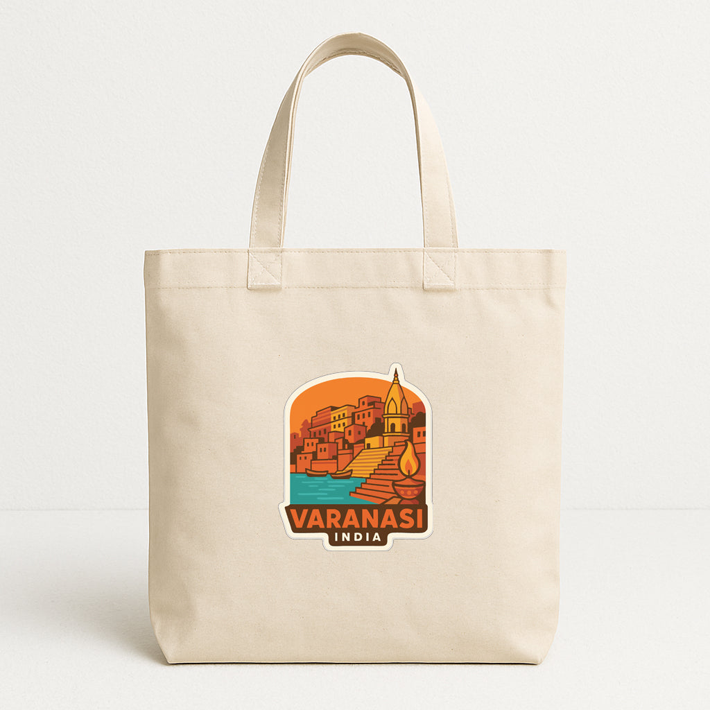A beige tote bag with a printed design depicting a cityscape and the text "VARANASI INDIA".