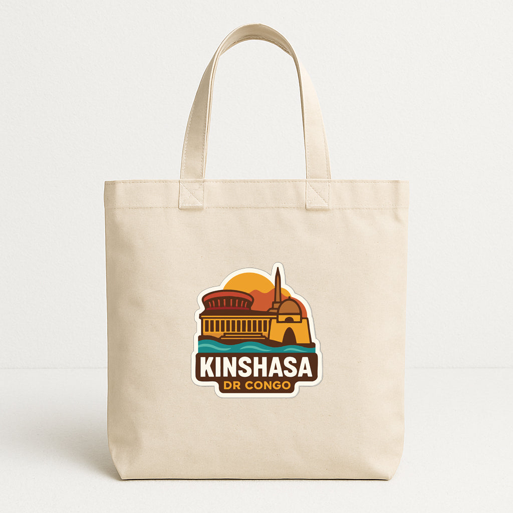 A beige tote bag with a graphic design featuring a building and the text "KINSHASA DR CONGO".