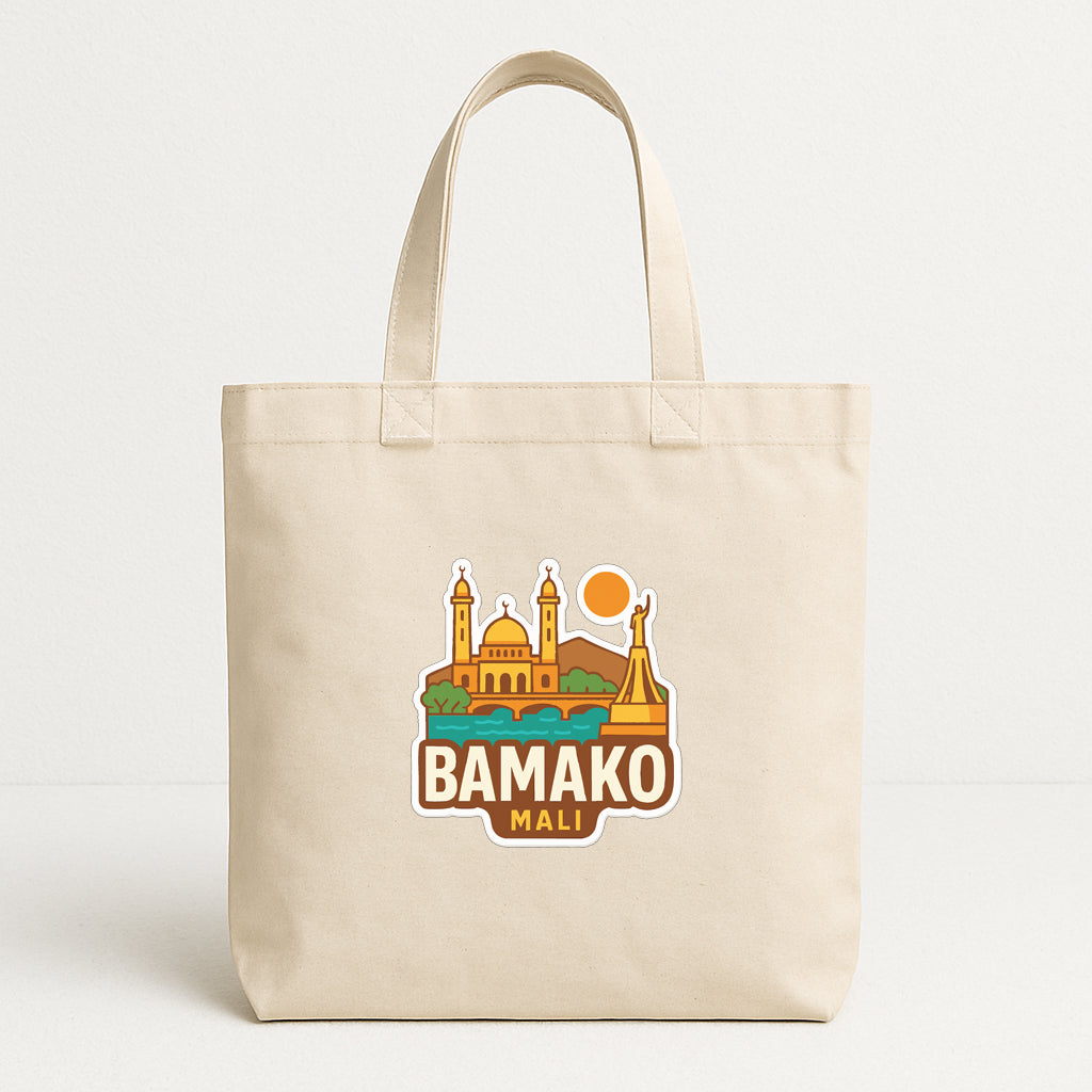 A beige tote bag with a printed graphic design featuring a city skyline and the text "BAMAKO MALI".