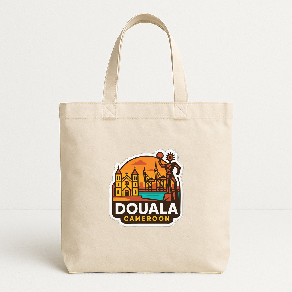 A beige tote bag with a colorful graphic design featuring a city skyline and a figure, along with the text "DOUALA CAMERON".