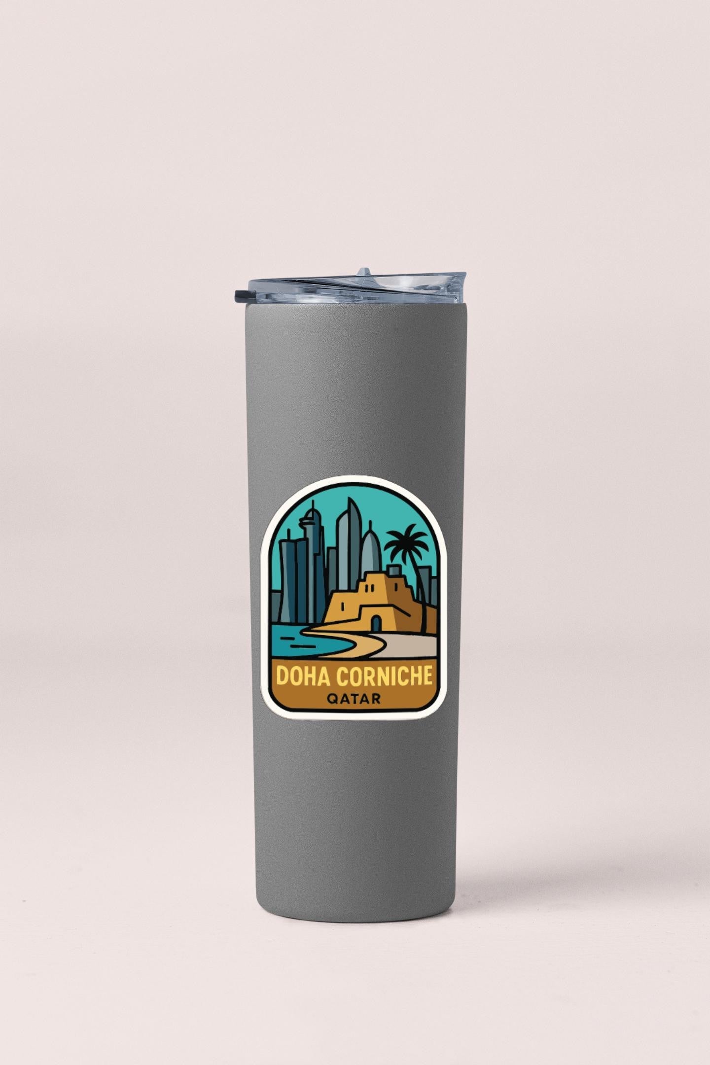 A gray insulated tumbler with a sticker depicting the Doha Corniche in Qatar.
