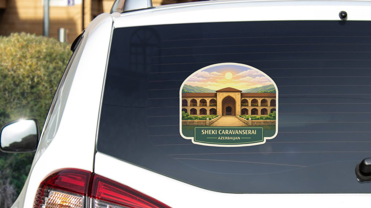 a sticker on the rear window of a car, depicting a building with arches and a sunset in the background.