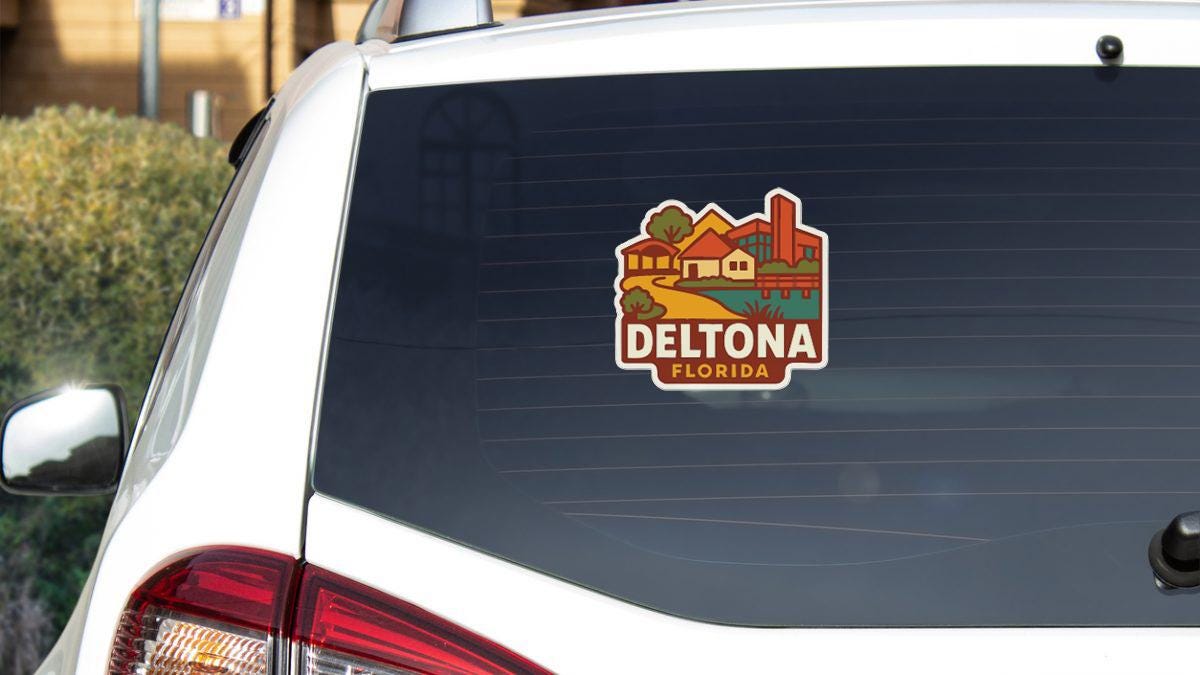 A sticker on the rear window of a white car that says "DELTONA FLORIDA".