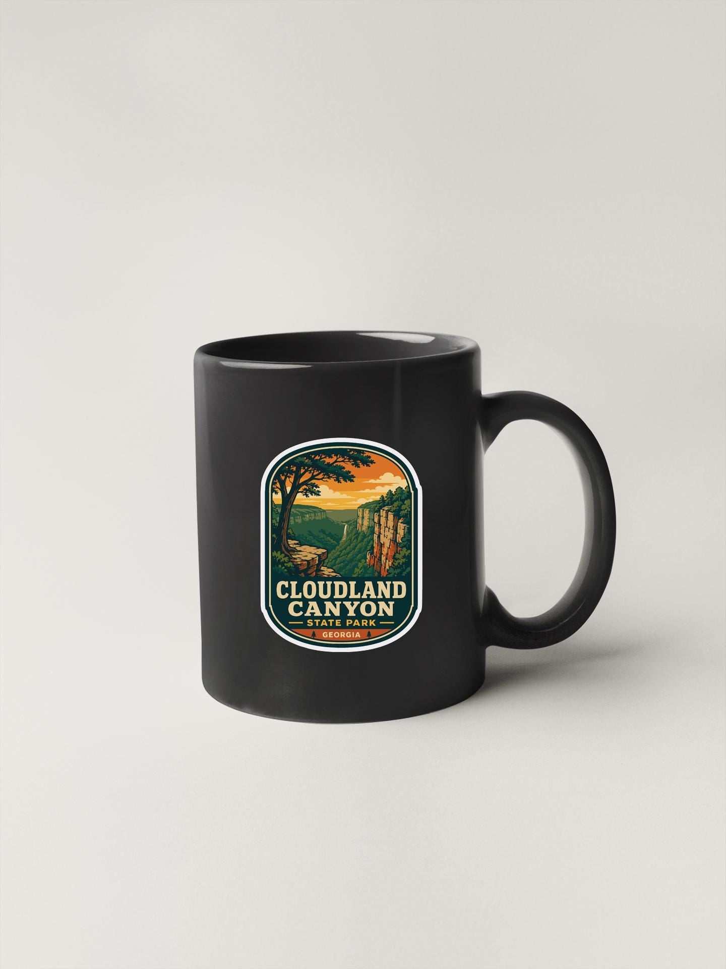 A black coffee mug with a graphic design depicting Cloudland Canyon, a famous national park in the United States.
