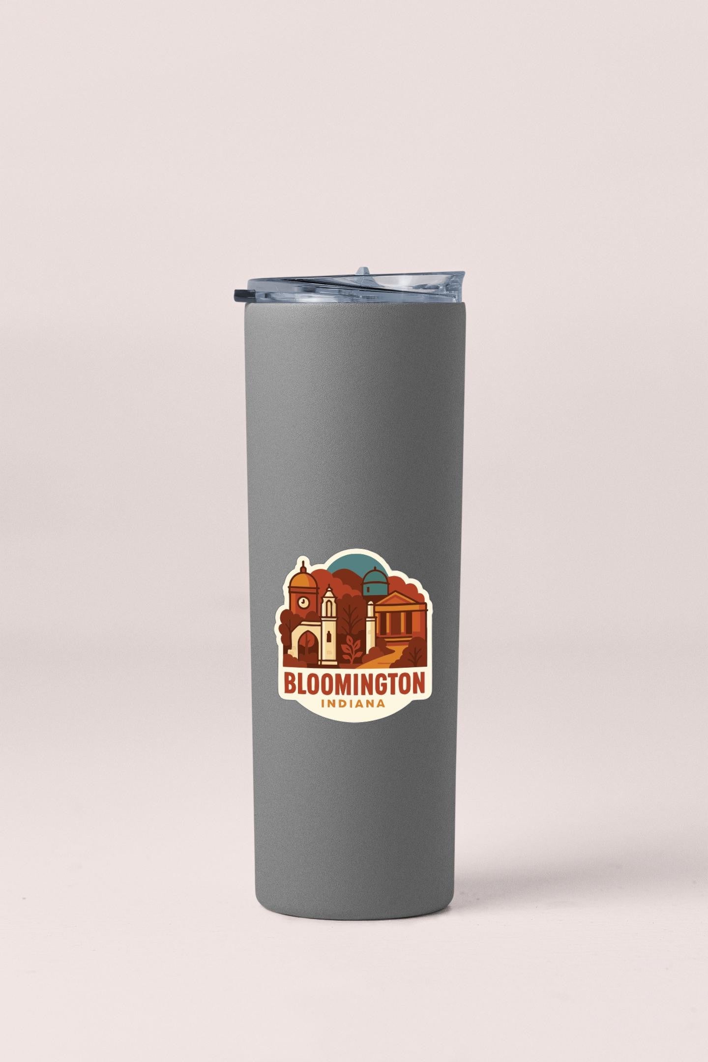 A gray insulated tumbler with a sticker depicting a cityscape and the text "Bloomsville, Indiana" printed on it.