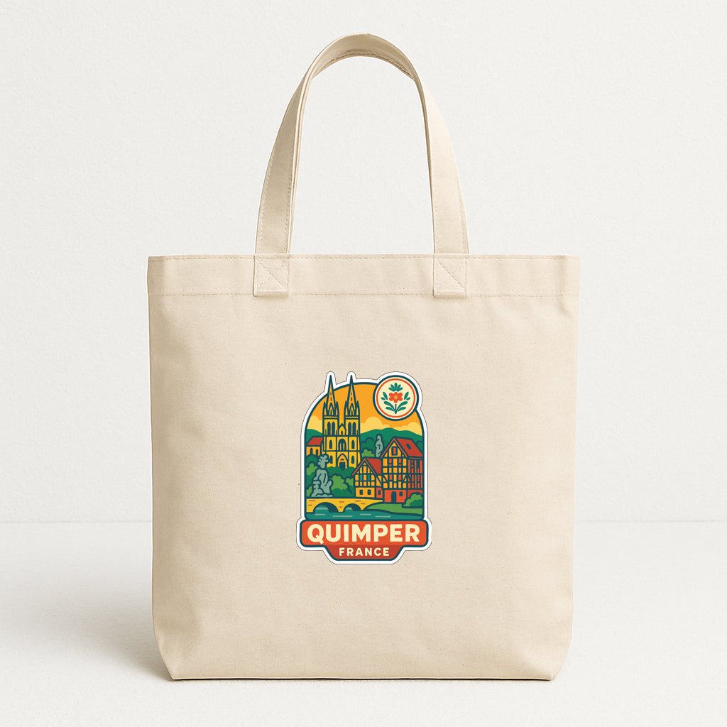 A beige tote bag with a colorful graphic of Quimper, France, printed on it.