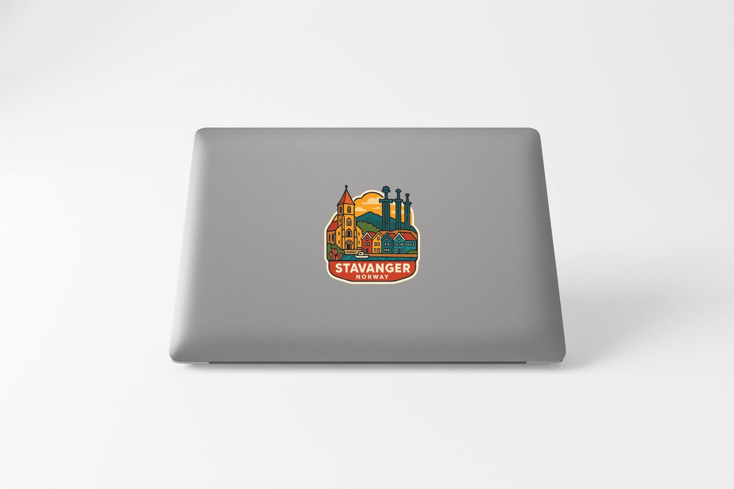 a sticker or decal on the back of a laptop, depicting a cityscape with a church and other buildings.