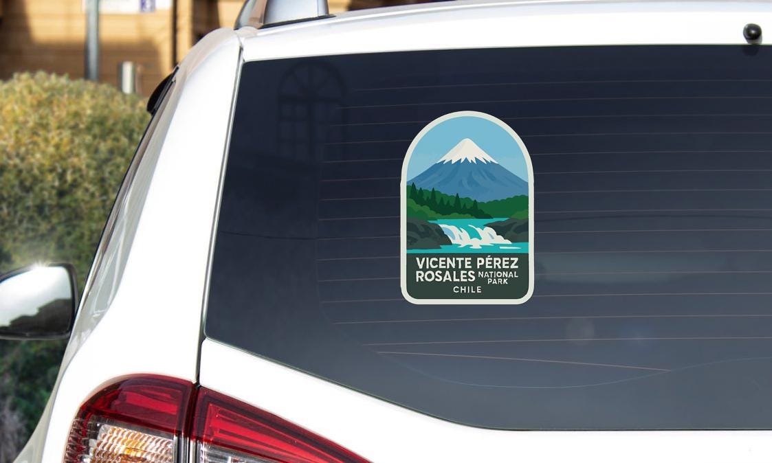 a sticker on the rear window of a car, depicting a mountain landscape with a waterfall.