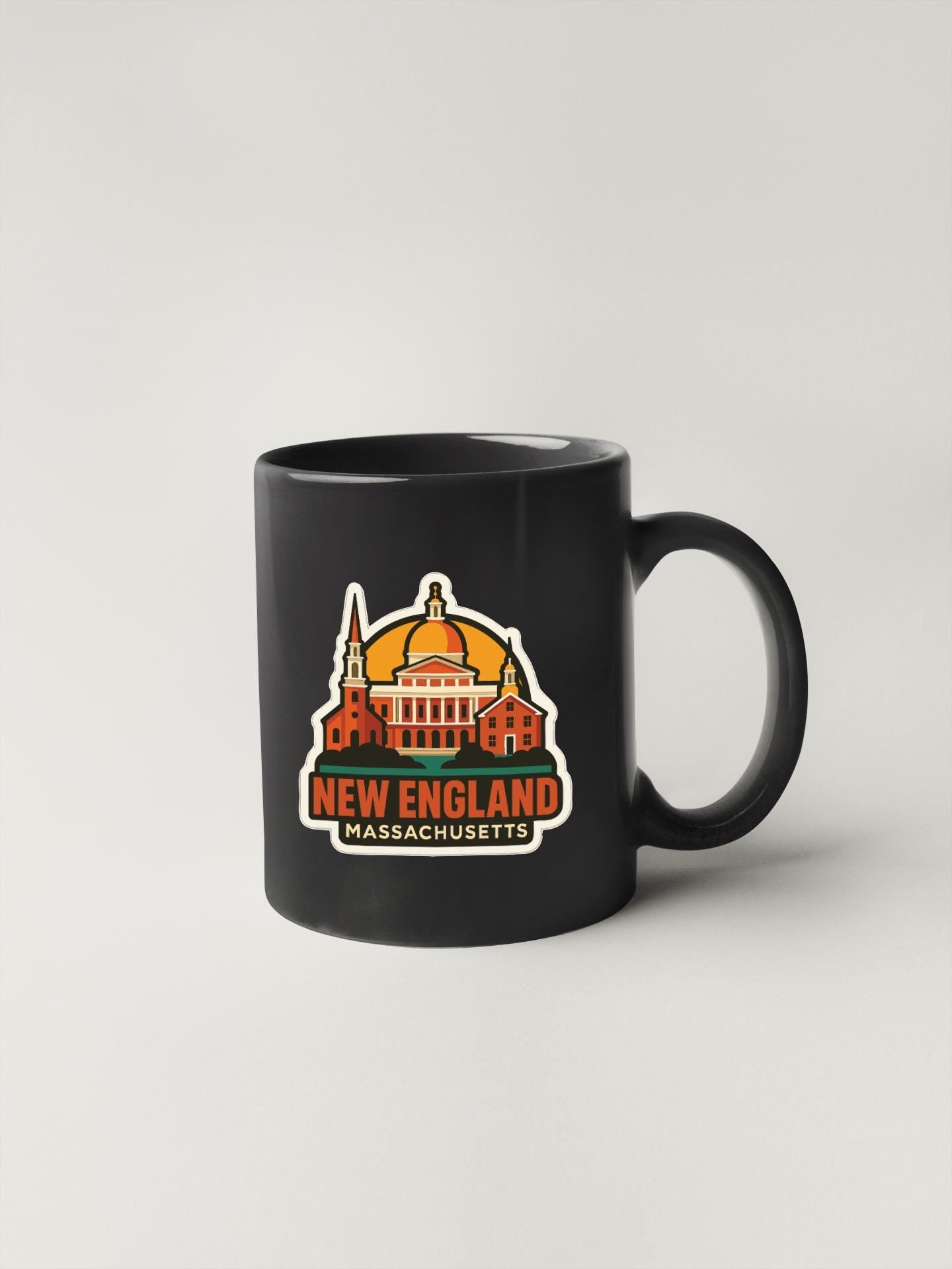 A black coffee mug with a graphic design depicting the state of Massachusetts, including a building and a dome.