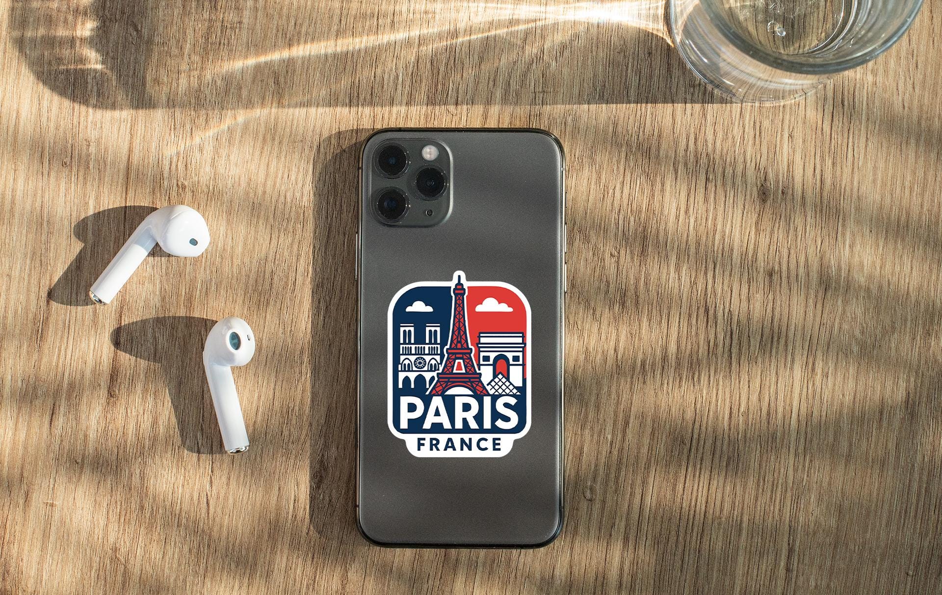 a phone with a sticker on it next to ear buds