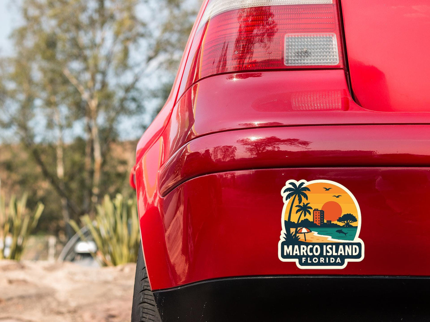 the rear end of a red car with a sticker on the back window that says "MARCO ISLAND FLORIDA".