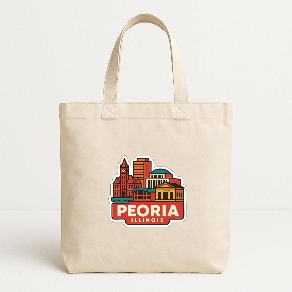 A beige tote bag with a colorful graphic of the city of Peoria, Illinois, printed on it.