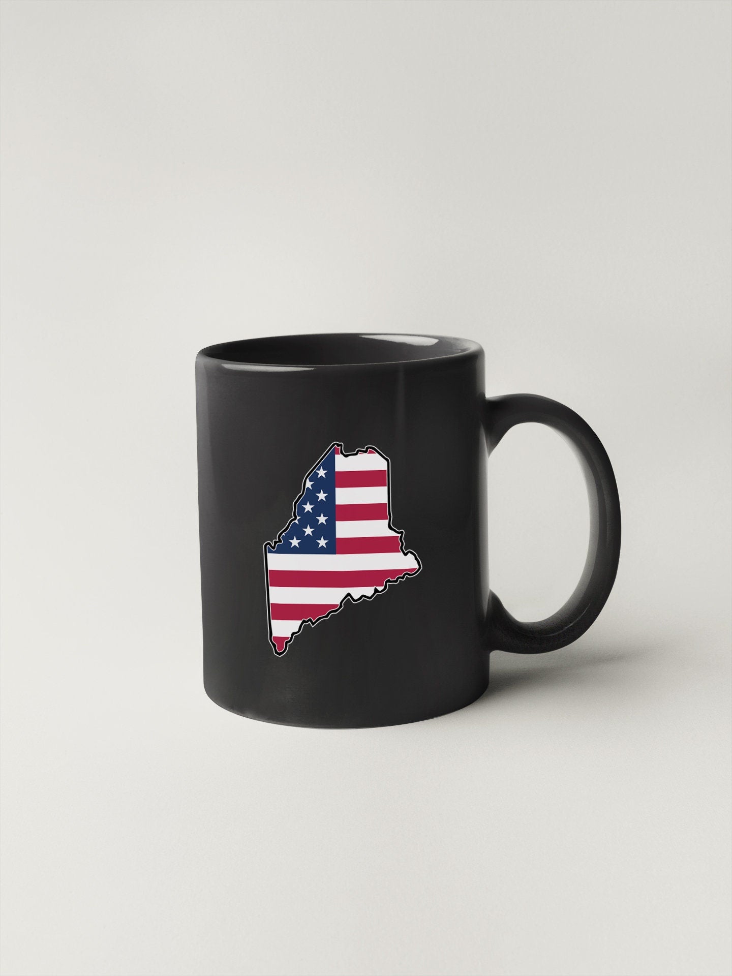 a black coffee mug with an american flag on it