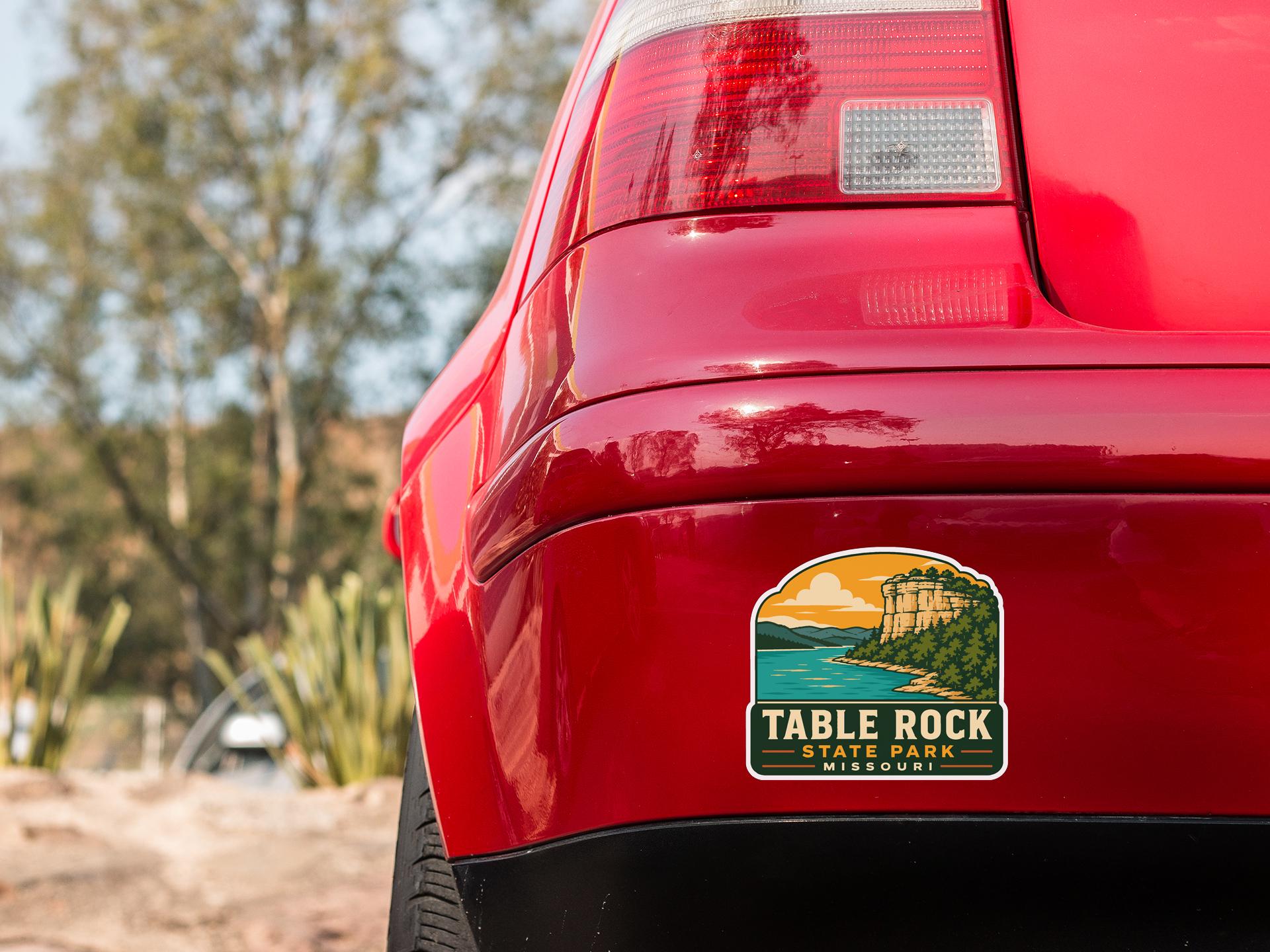 the rear end of a red car with a sticker on the back window that says "Table Rock State Park, Missouri".