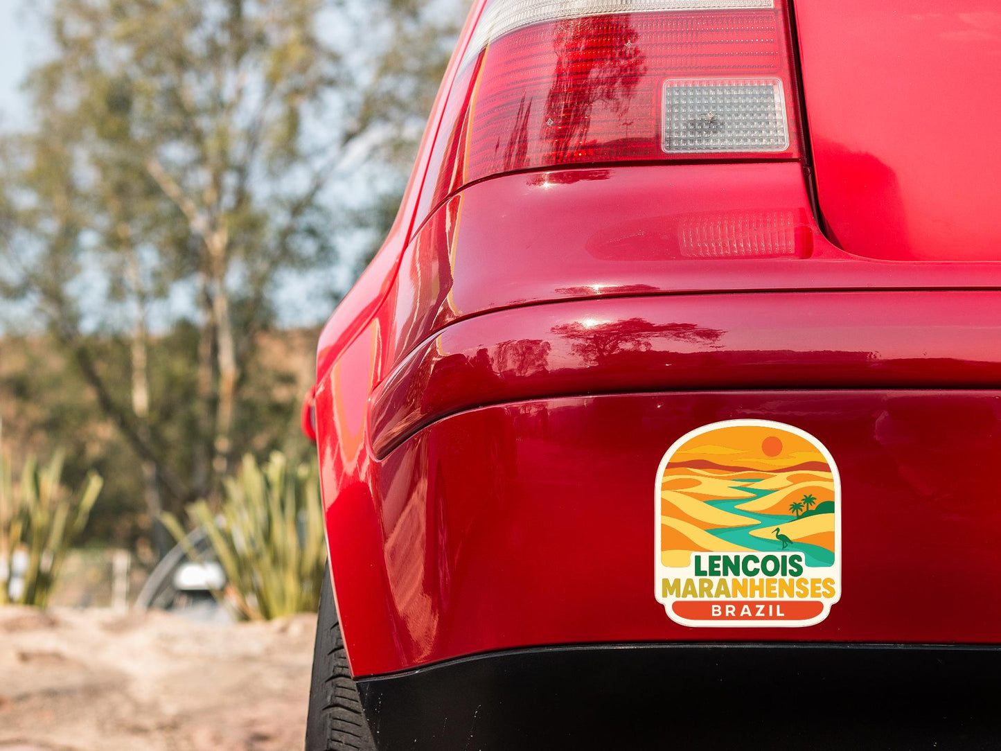the rear end of a red car with a sticker on the back window that says "LENCOIS MARANHENSES BRAZIL".