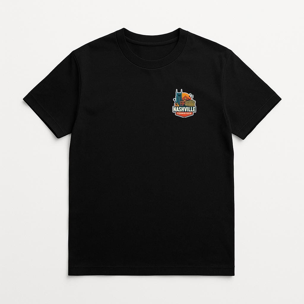 A black t-shirt with a graphic design on the left side, depicting a city skyline with a prominent building.
