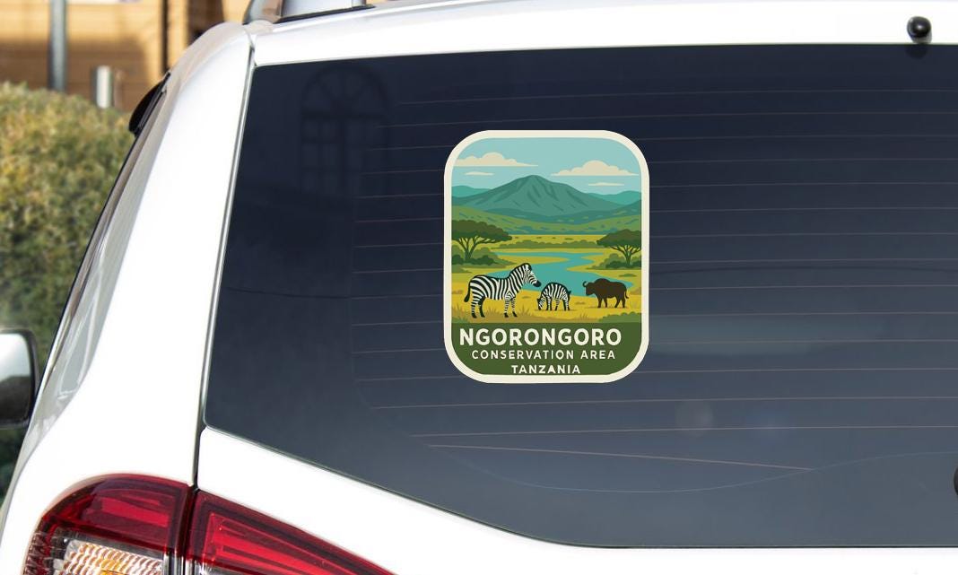 a sticker on the rear window of a vehicle, depicting a scenic landscape with zebras, a mountain, and a river.