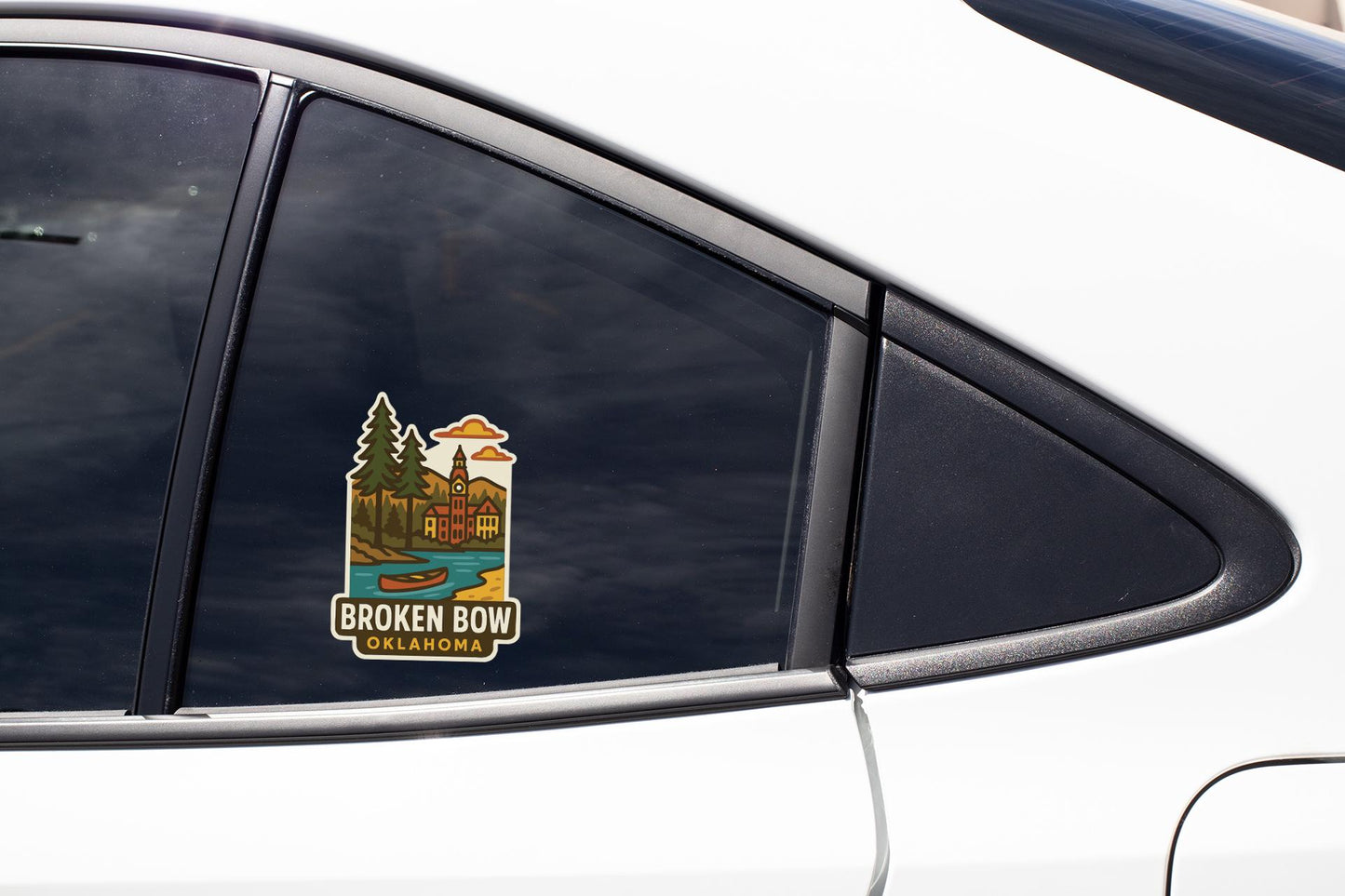 A sticker on the side of a car window, depicting a scenic landscape with a lake and mountains.