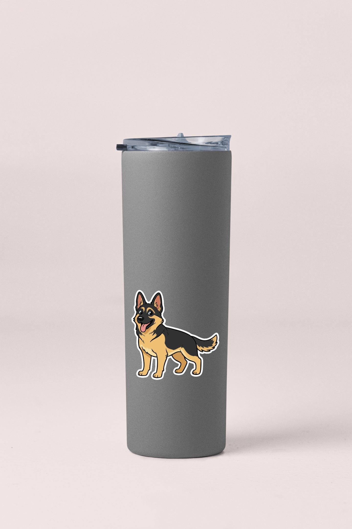 A gray insulated tumbler with a sticker of a German Shepherd dog on it.