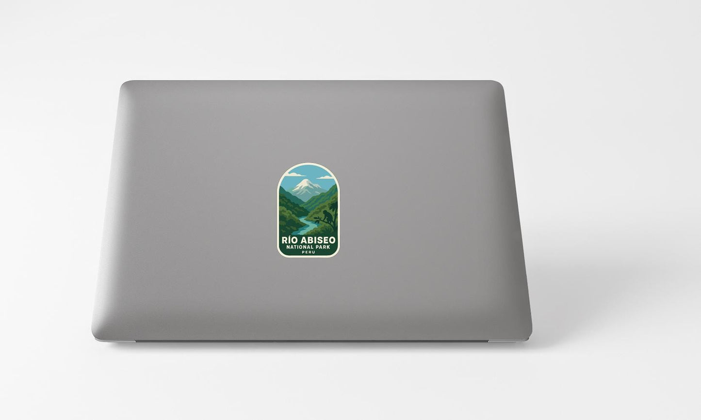 A sticker with a mountain landscape and the text "Rio Abisio National Park" printed on a grey laptop.