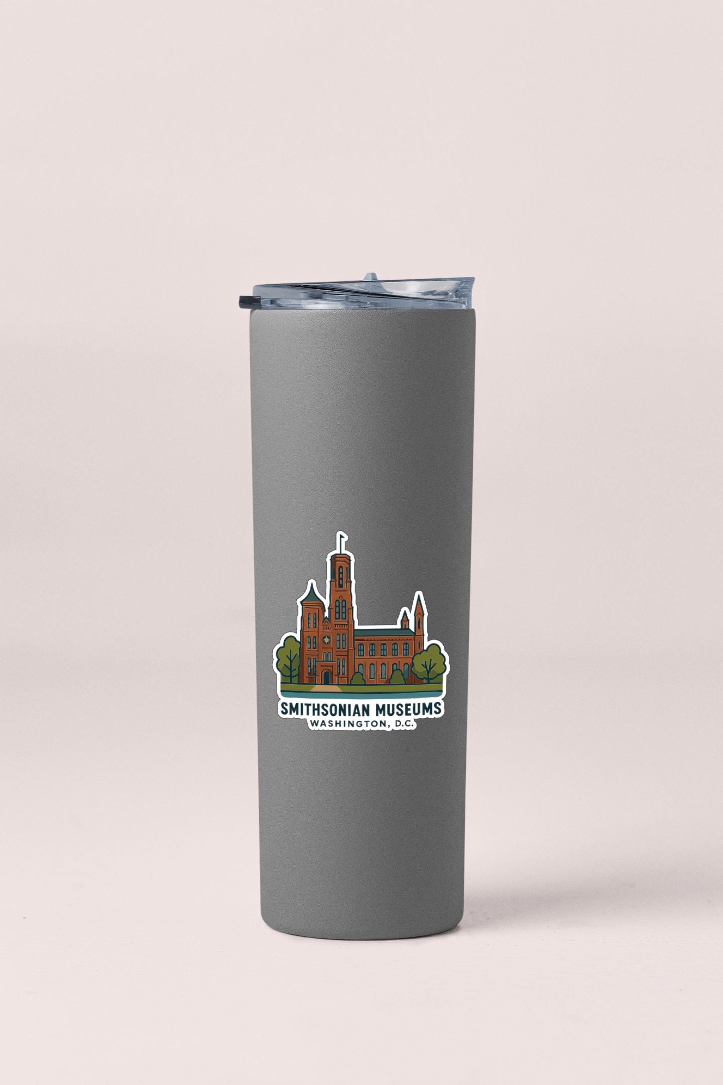 A gray tumbler with a sticker depicting a building and the text "Smithsonian Museums Washington, DC" printed on it.