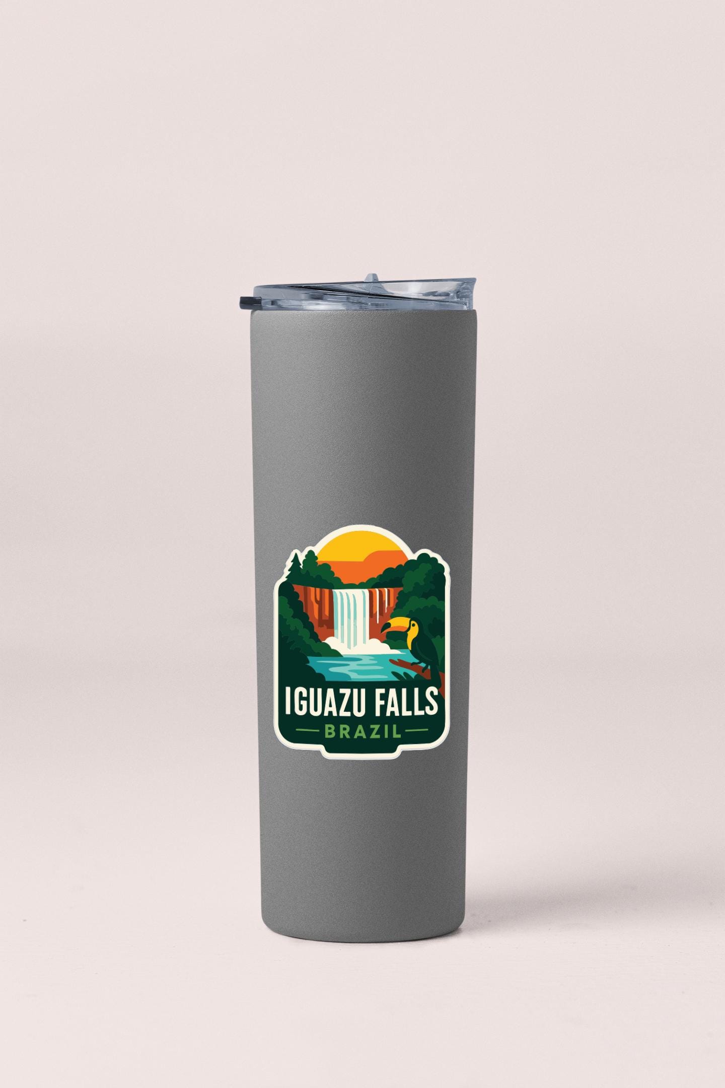 A gray insulated tumbler with a sticker depicting the scenic Iguazu Falls in Brazil.