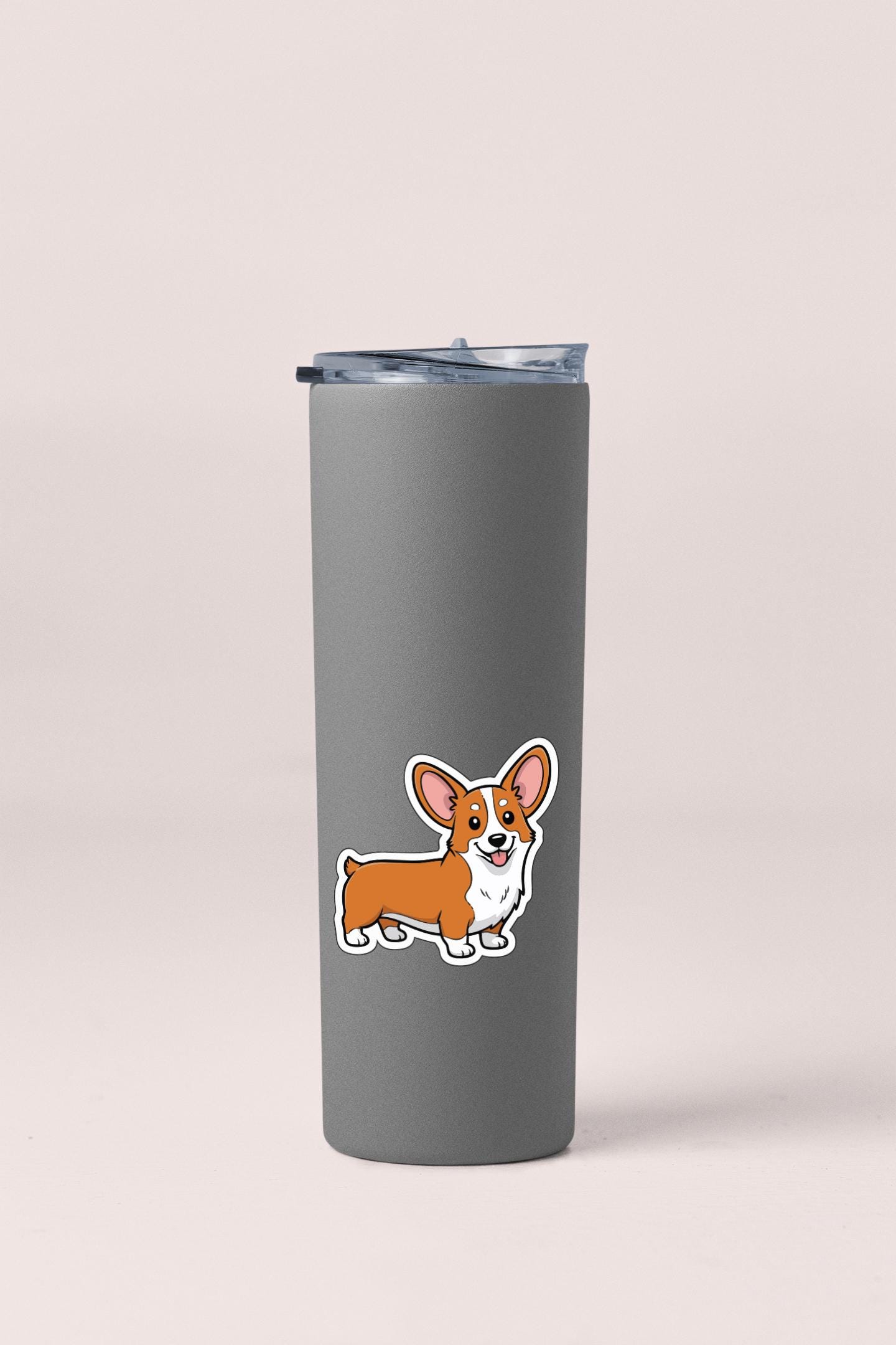 A gray insulated tumbler with a cartoon image of a corgi dog printed on it.