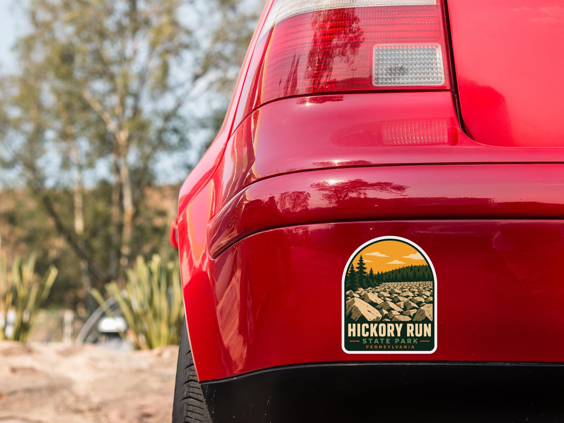 the rear end of a red car with a sticker on the bumper that says "Hickory Run" and "Pennsylvania".