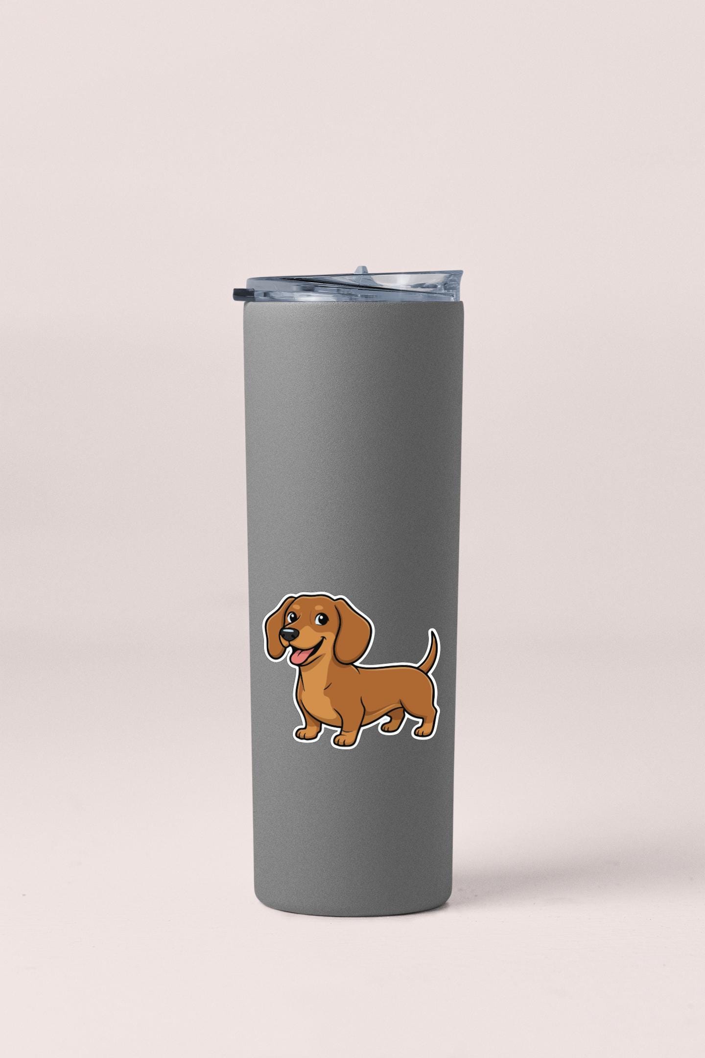 A gray insulated tumbler with a cartoon illustration of a brown dachshund dog on it.
