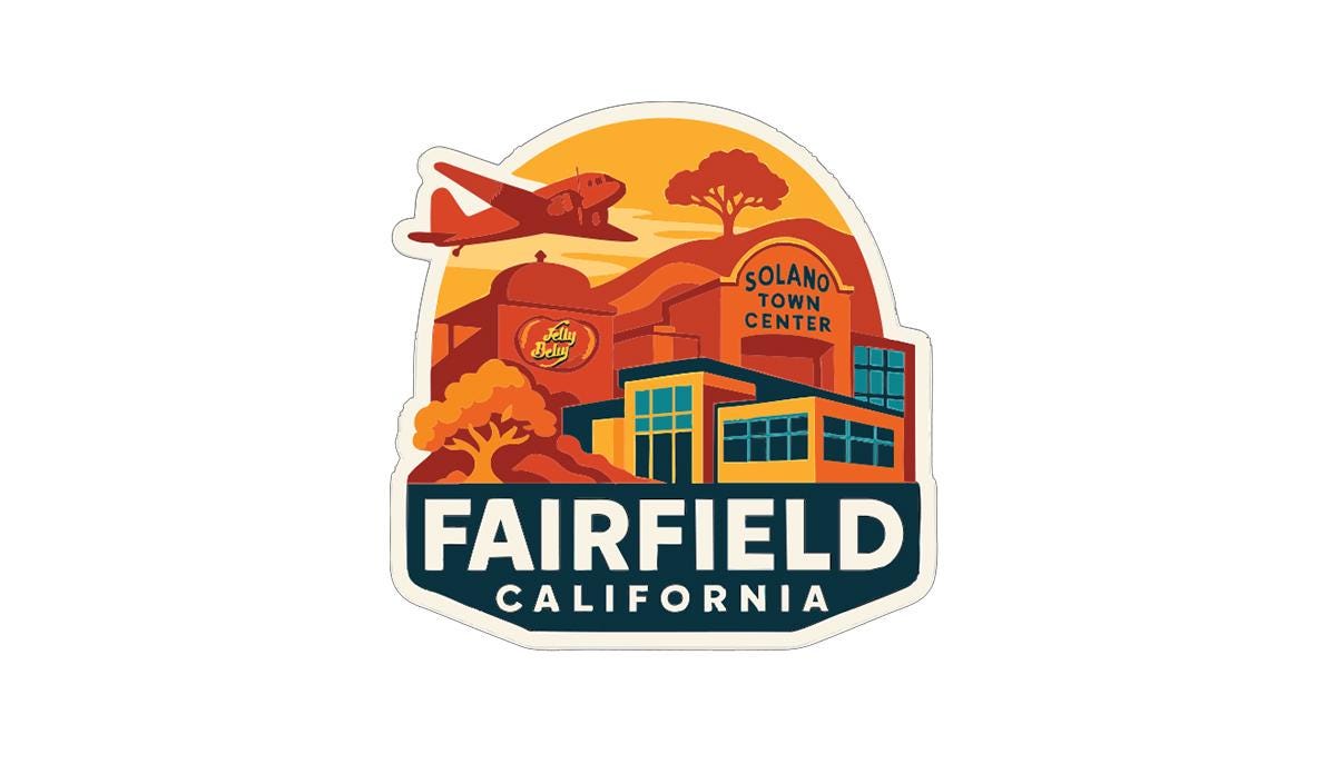a sticker or emblem with various elements representing the town of Fairfield, California. It includes a building, a plane, and a sunset, all set against a warm, orange and yellow background. The text "FAIRFIELD CALIFORNIA" is prominently displayed, indicating the location of the town.
