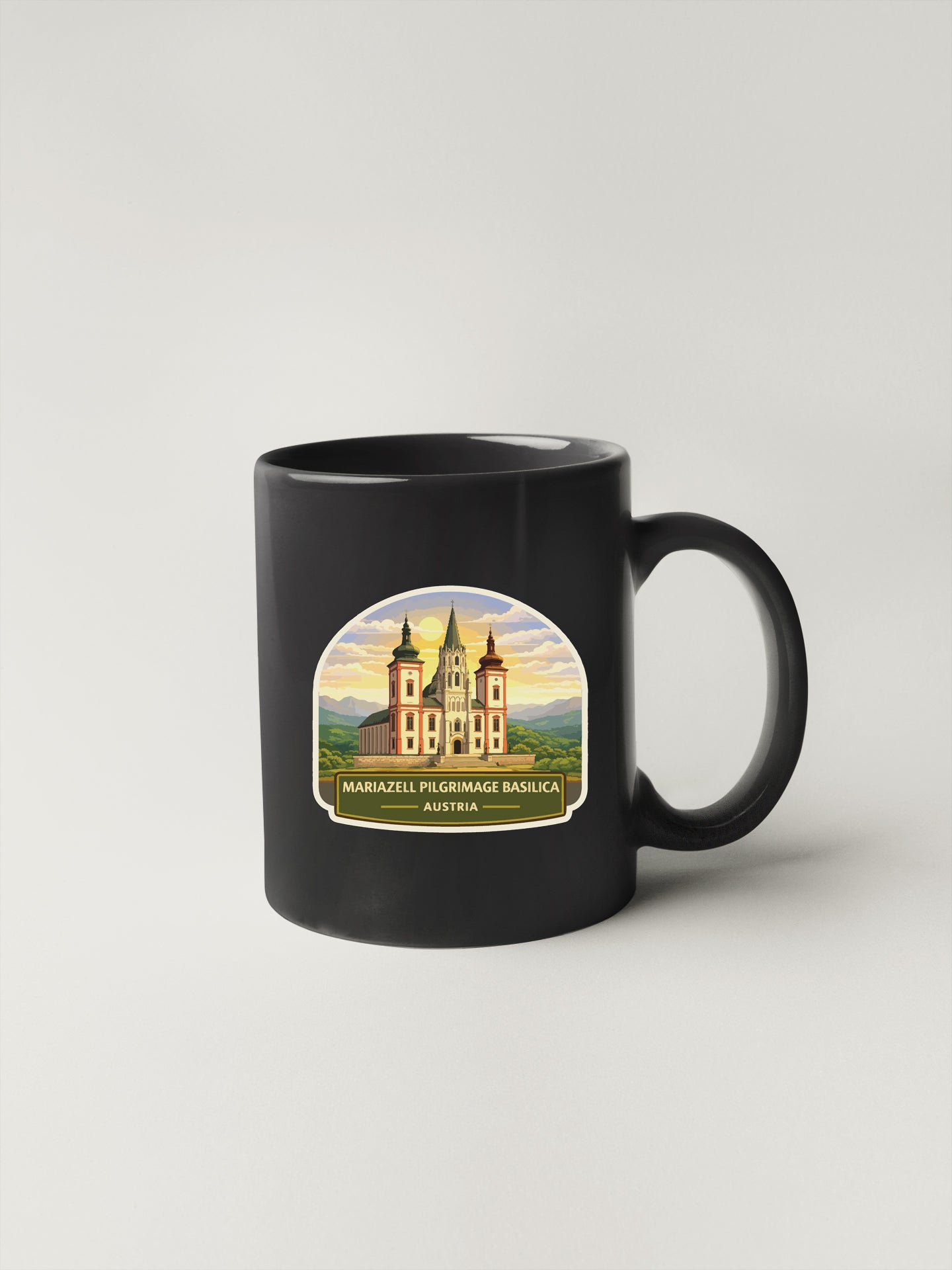 A black coffee mug with a label depicting a castle and the text "MARIZZELL PILGRIMAGE BASICAI AUSTRIA".