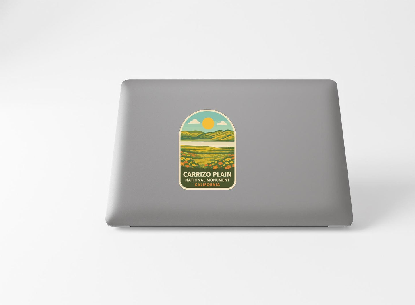 a sticker with a landscape and a sun graphic on a laptop.