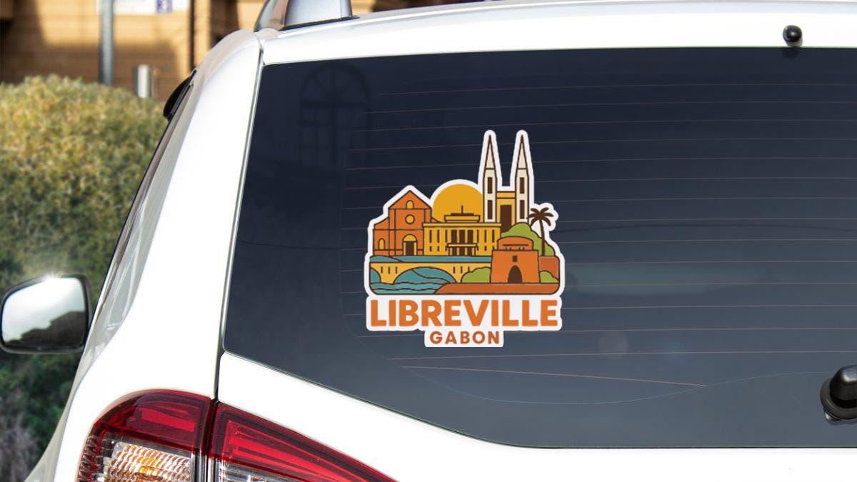 A sticker on the rear window of a car that displays the city of Libreville, Gabon.