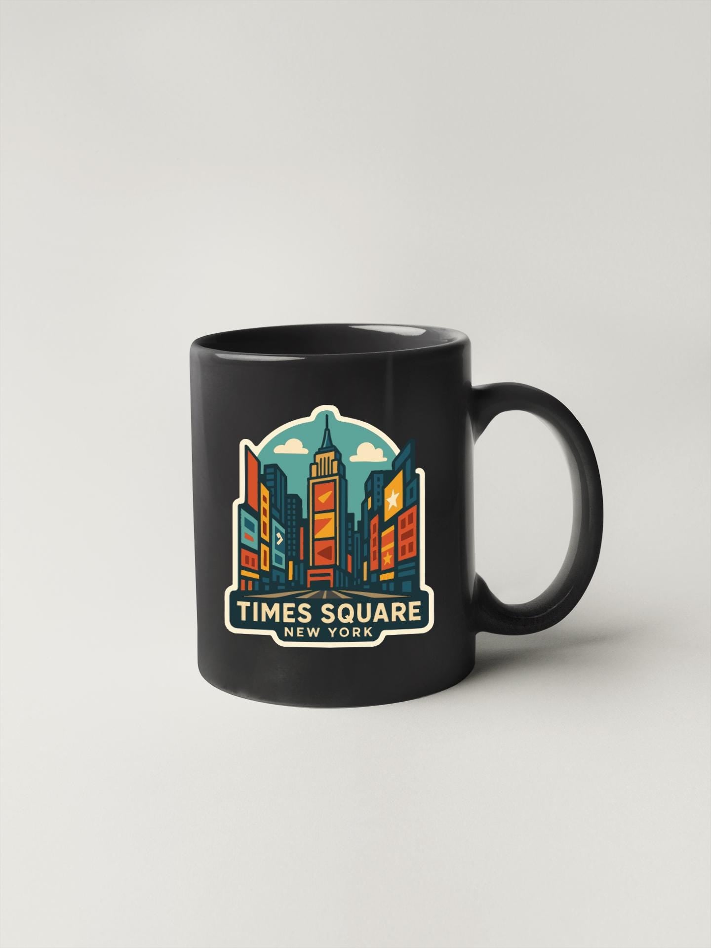 A black coffee mug with a colorful illustration of Times Square in New York City.