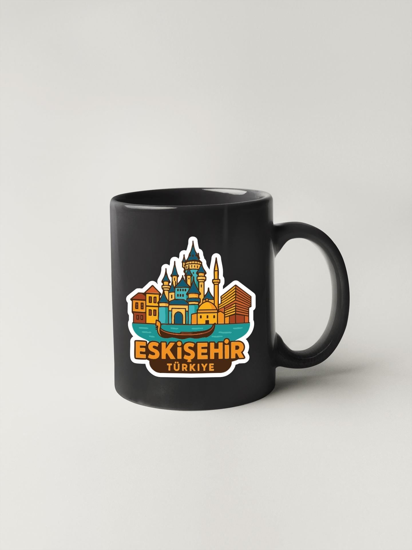 A black coffee mug with a colorful illustration of the skyline of Istanbul, Turkey, featuring the Eskisehir skyline.