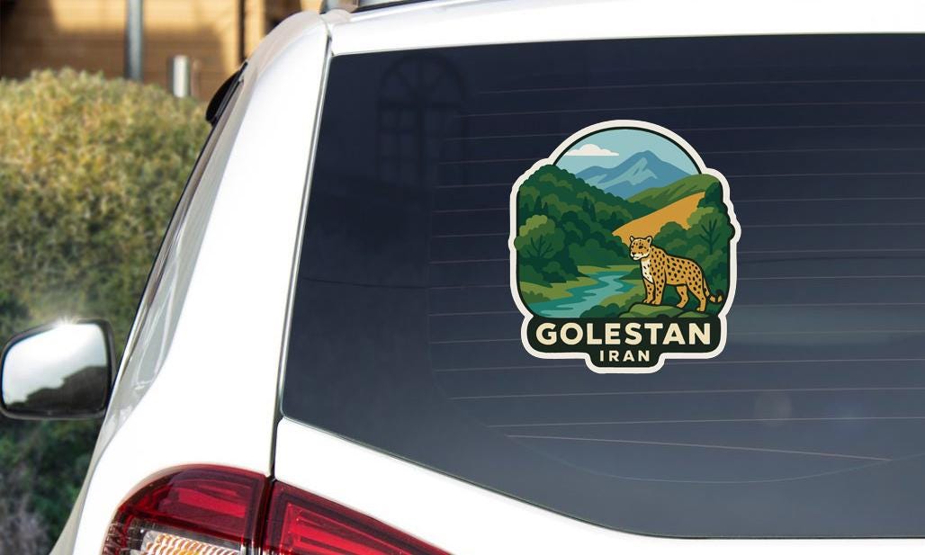 A sticker on the rear window of a car, depicting a scenic landscape with mountains, a river, and a leopard.