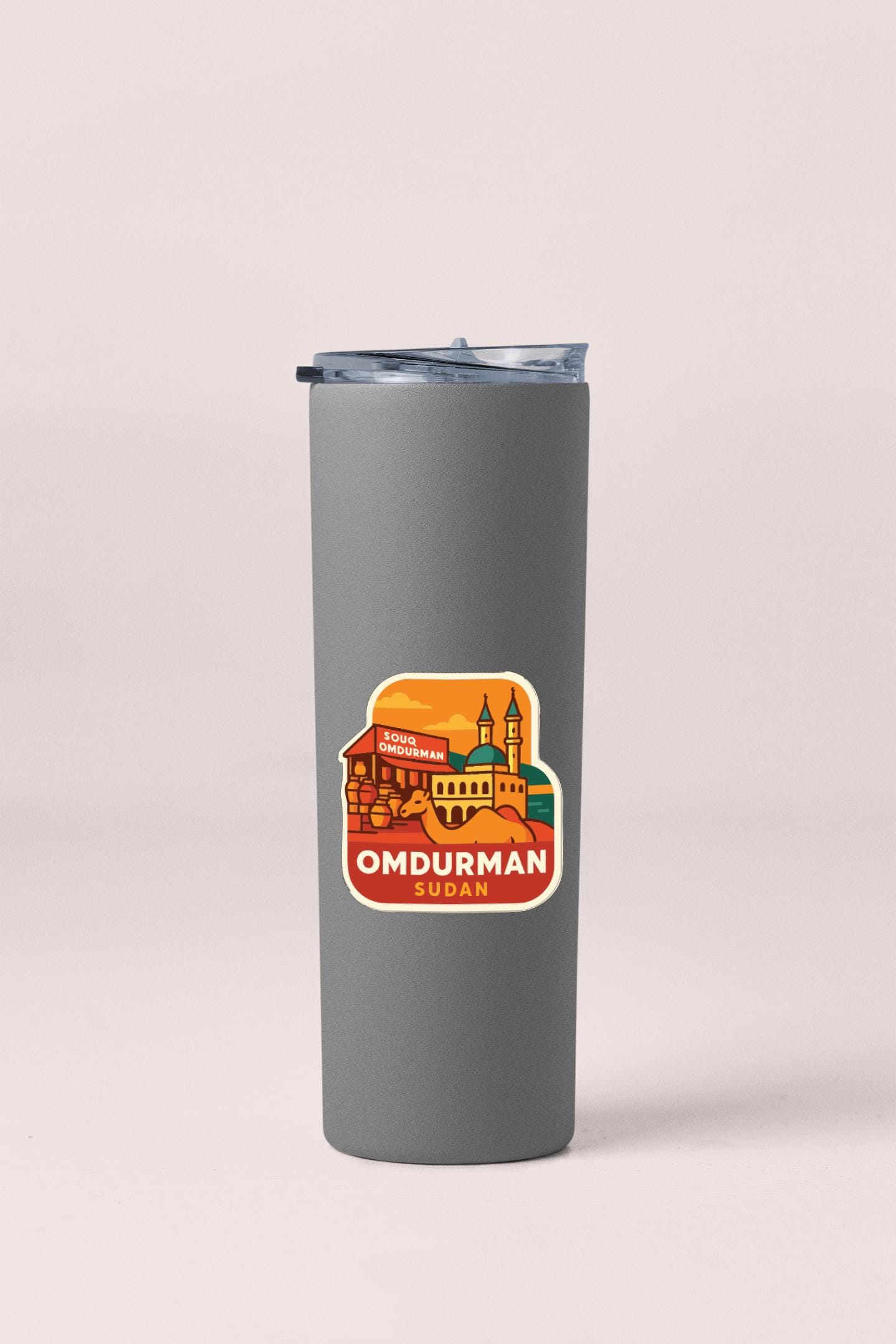 A gray insulated tumbler with a sticker depicting a cityscape and the text "OMDURMAN SUDAN" printed on it.