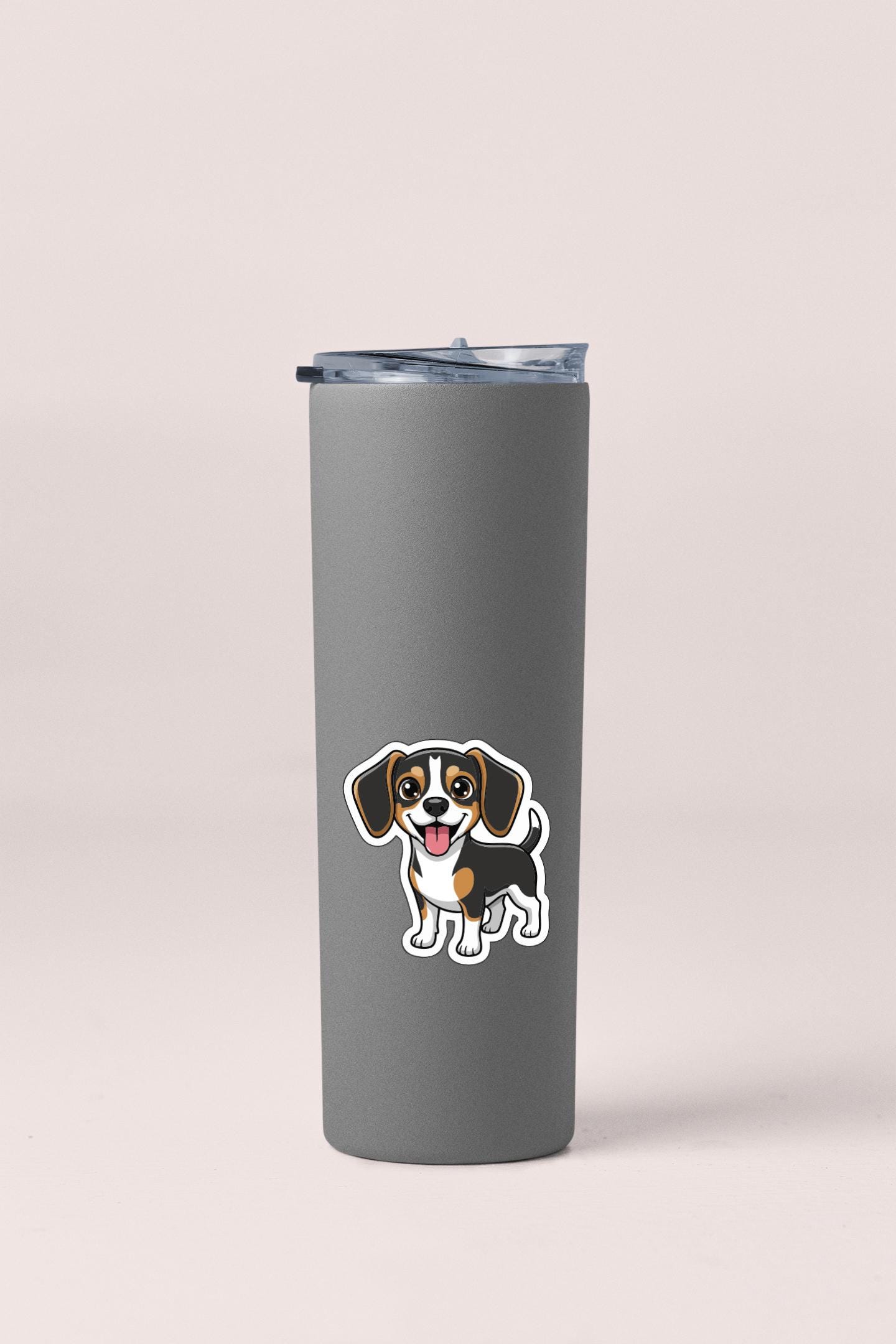 A gray insulated tumbler with a sticker of a cartoon dog on it.