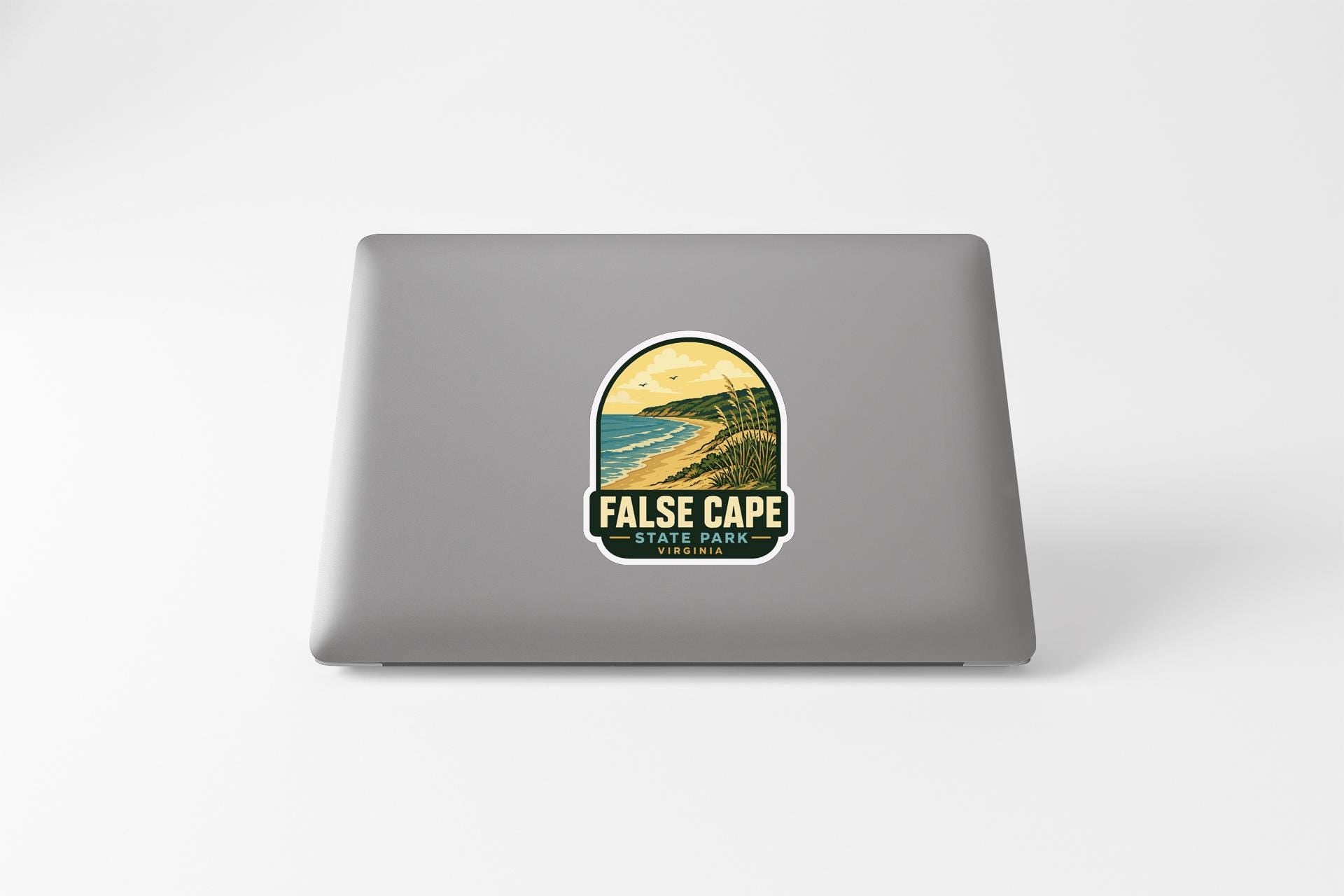 a sticker with a scenic landscape of a beach and mountains, along with the text "FALSE CAPE STATE PARK".
