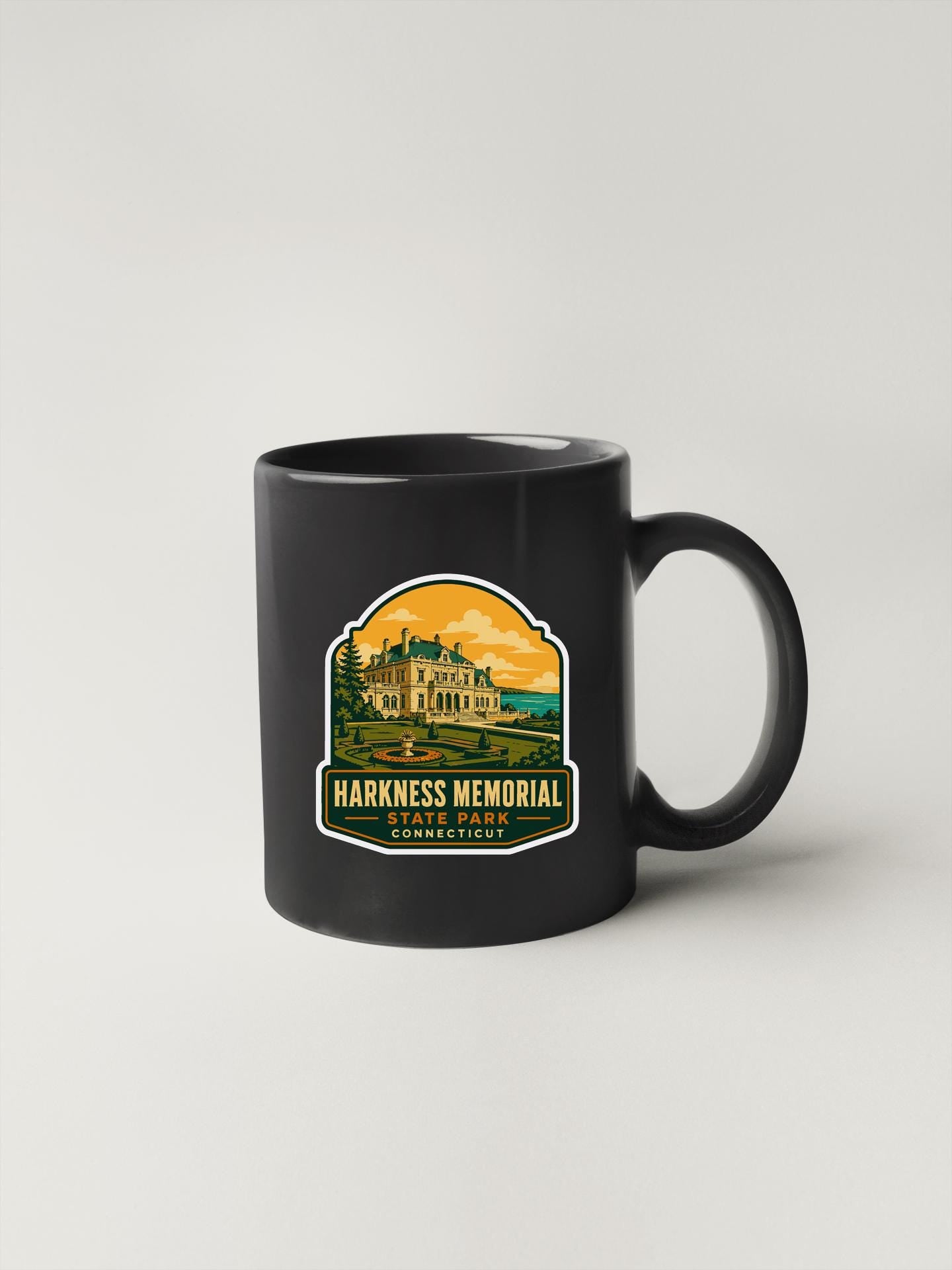 A black coffee mug with a graphic design depicting a memorial for the Harkness Memorial, which is located in Stone Park, Connecticut.