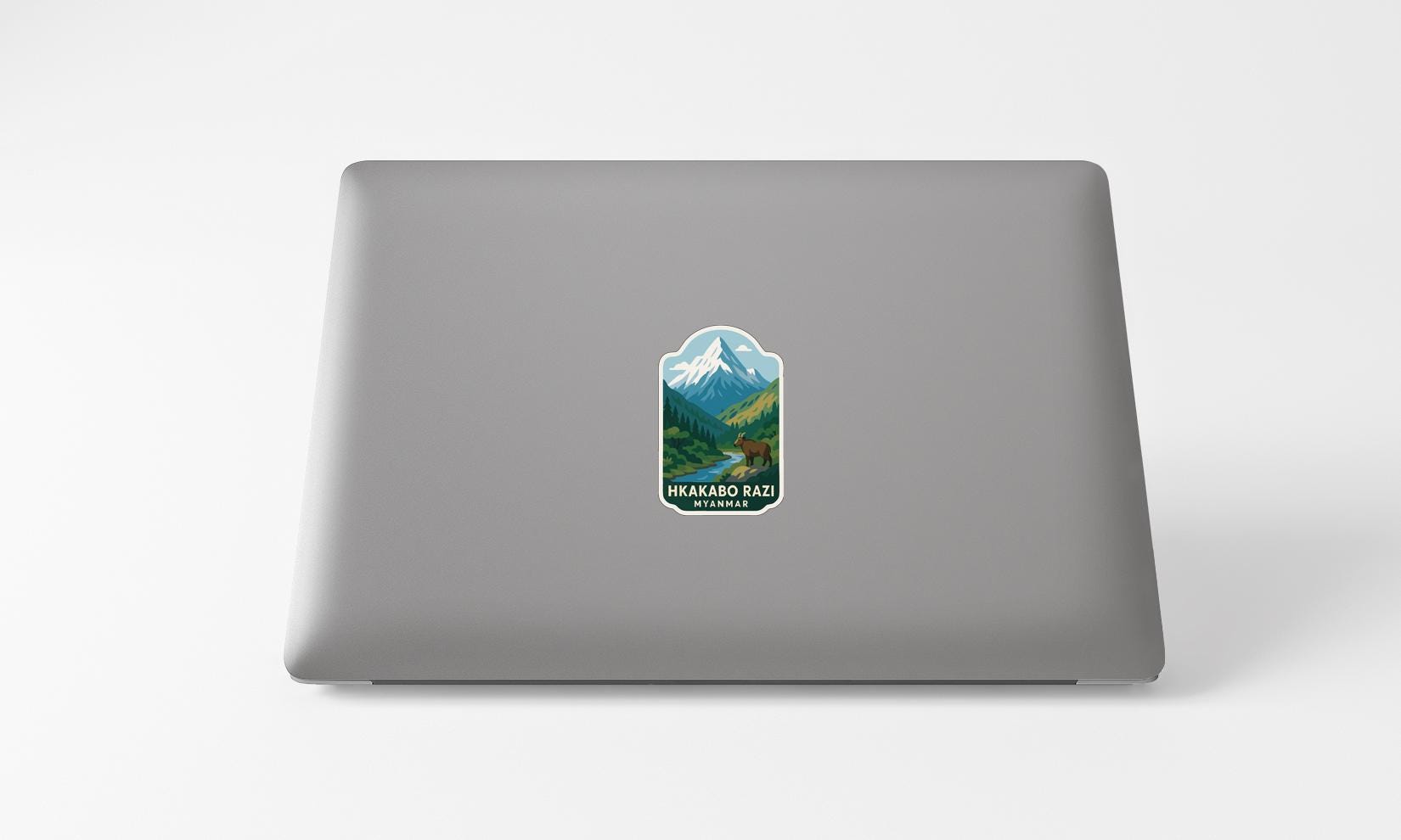 A sticker with a mountain landscape on a laptop.
