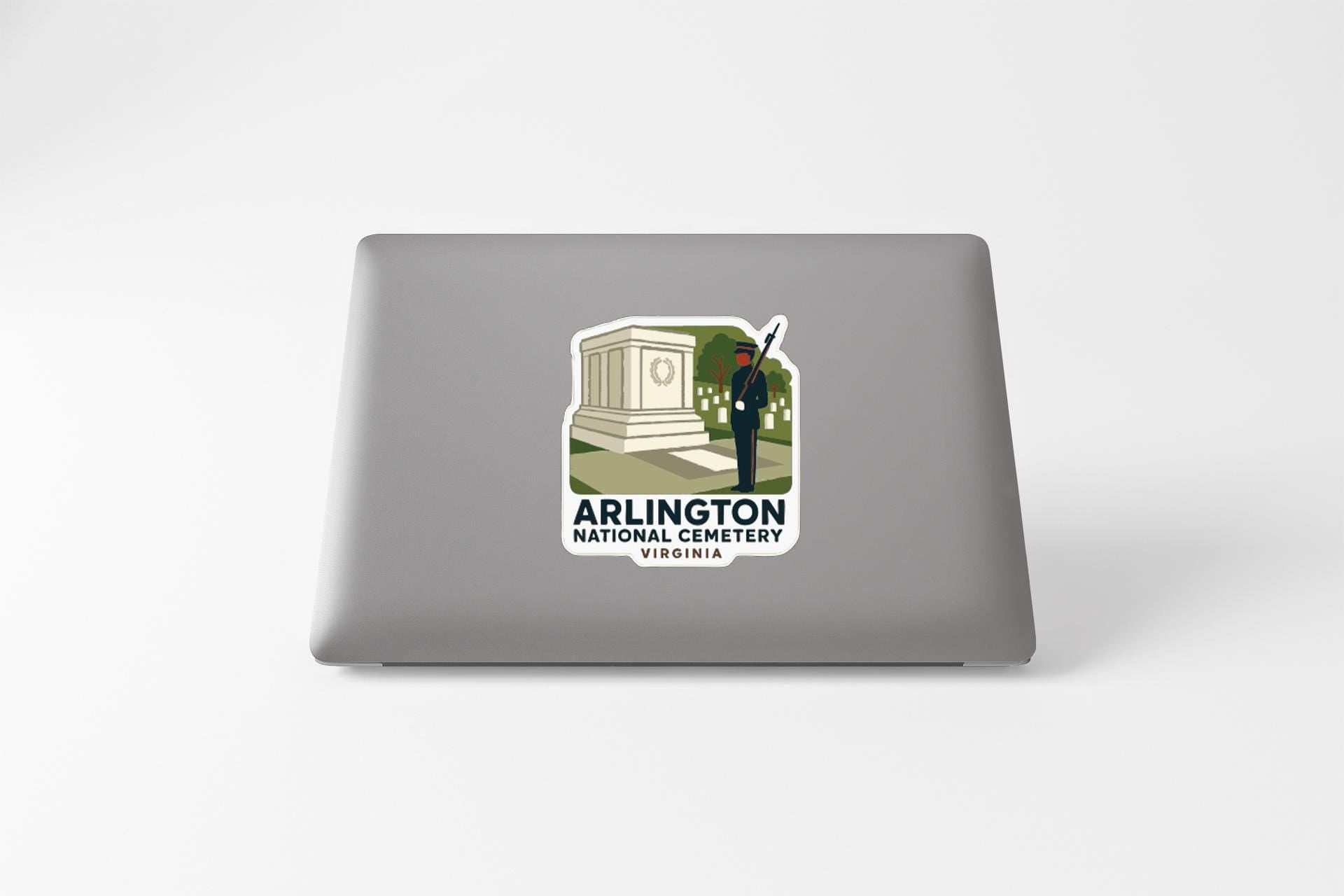 a sticker on a laptop that displays an illustration of a monument and a person, along with the text "ARLINGTON NATIONAL CEMERY VIRGINIA".